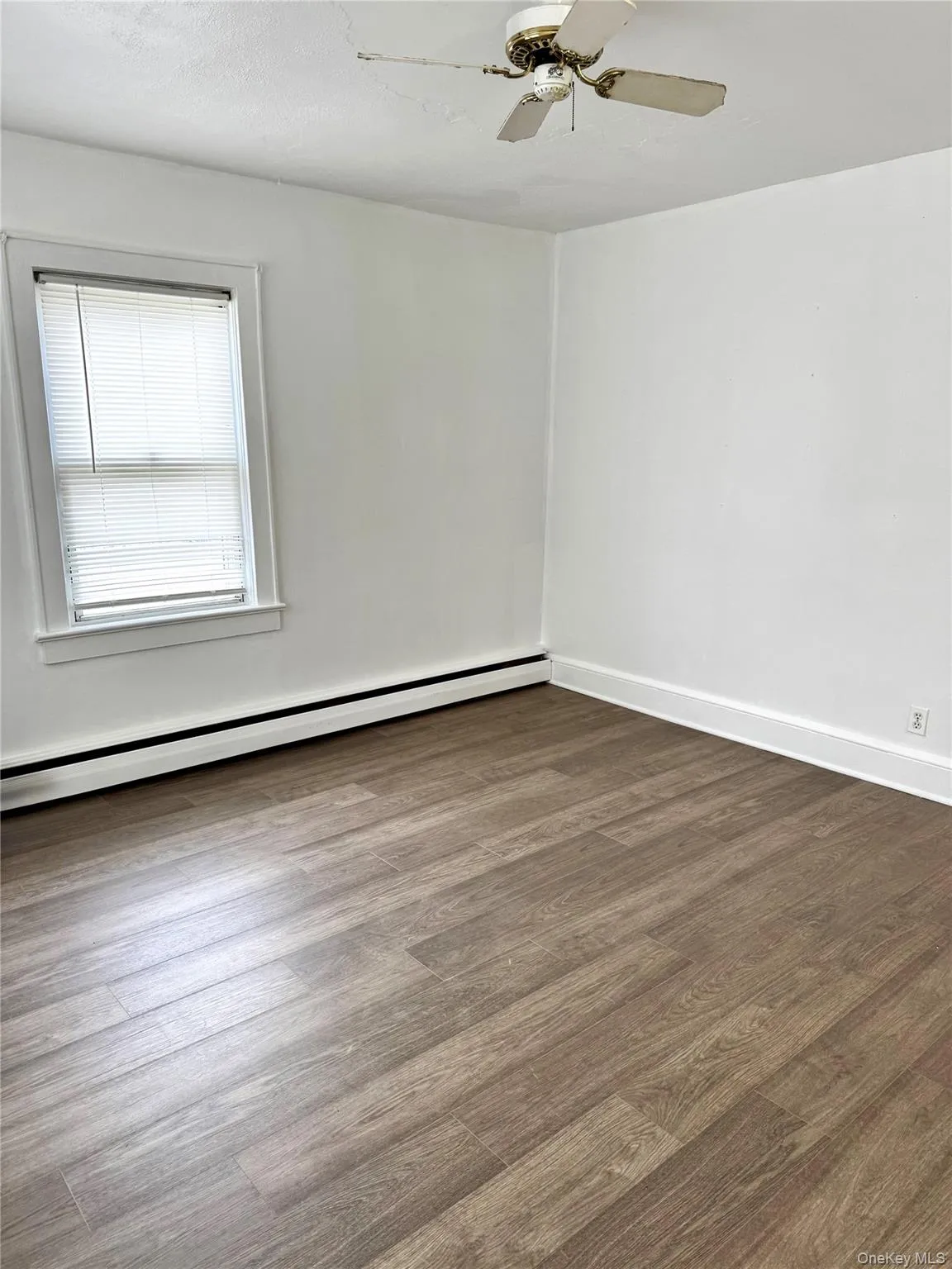 featuring baseboard heating, wood finished floors, and ceiling fan featuring baseboard heating, wood finished floors, and ceiling fan