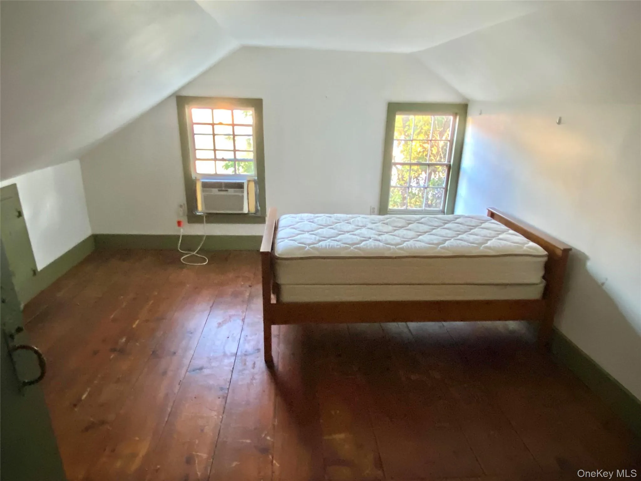 Bedroom with lofted ceiling, wood-type flooring, and cooling unit Bedroom with lofted ceiling, wood-type flooring, and cooling unit