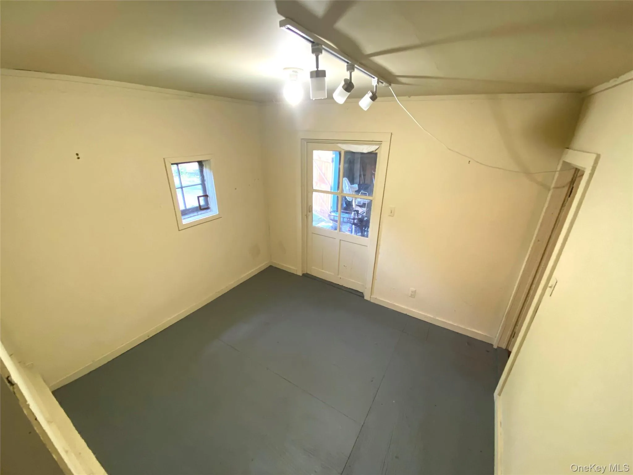 Unfurnished dining area featuring baseboards and rail lighting Unfurnished dining area featuring baseboards and rail lighting