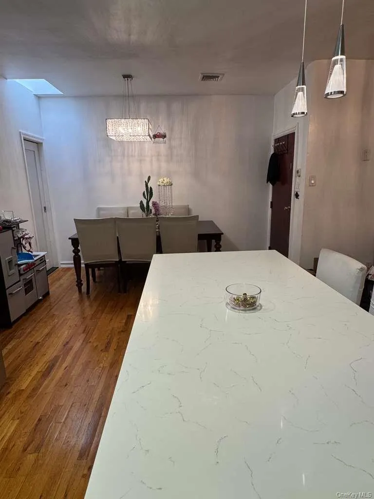 Dining area featuring dark wood-style flooring and a chandelier Dining area featuring dark wood-style flooring and a chandelier