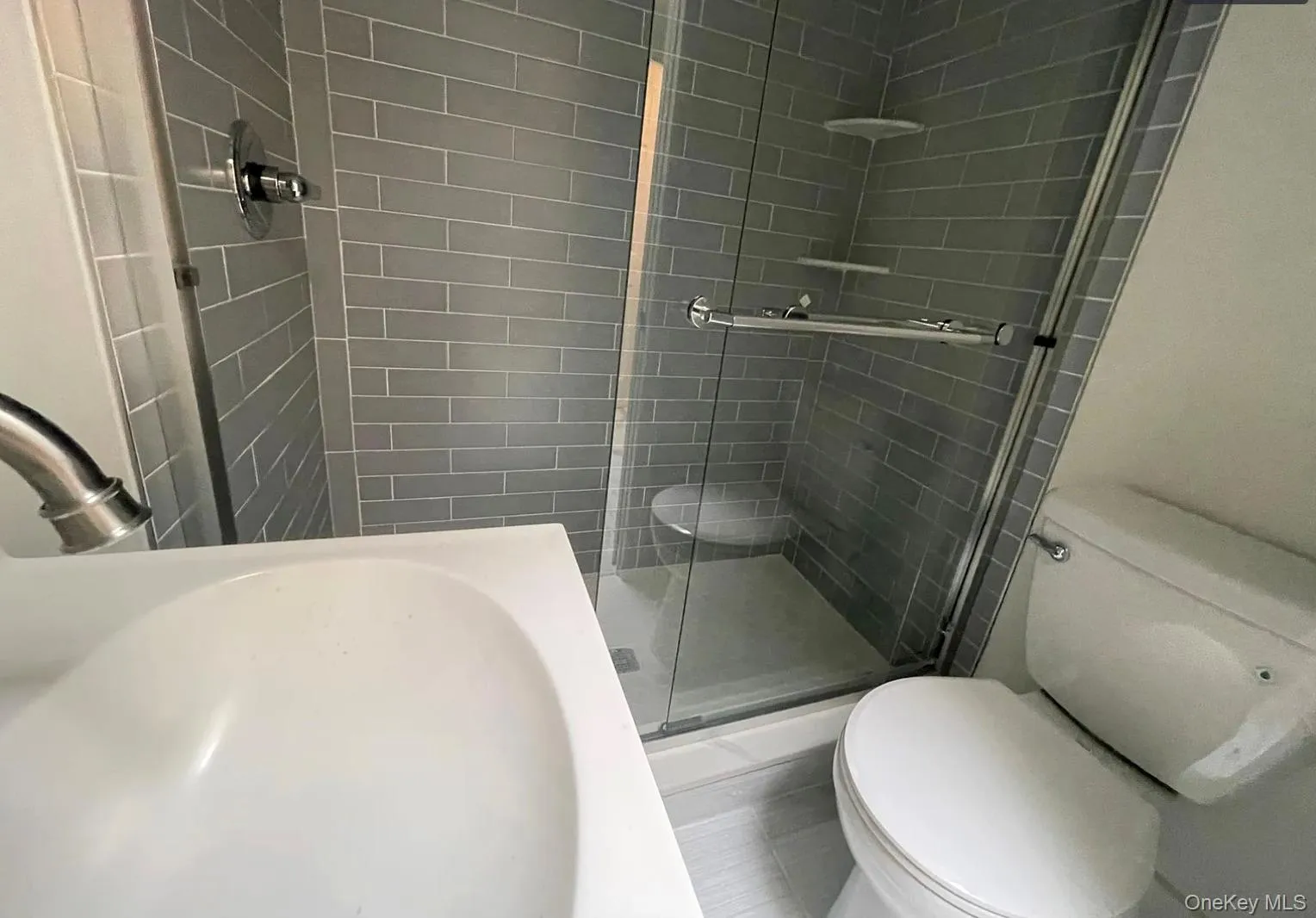 Bathroom featuring toilet and a stall shower Bathroom featuring toilet and a stall shower