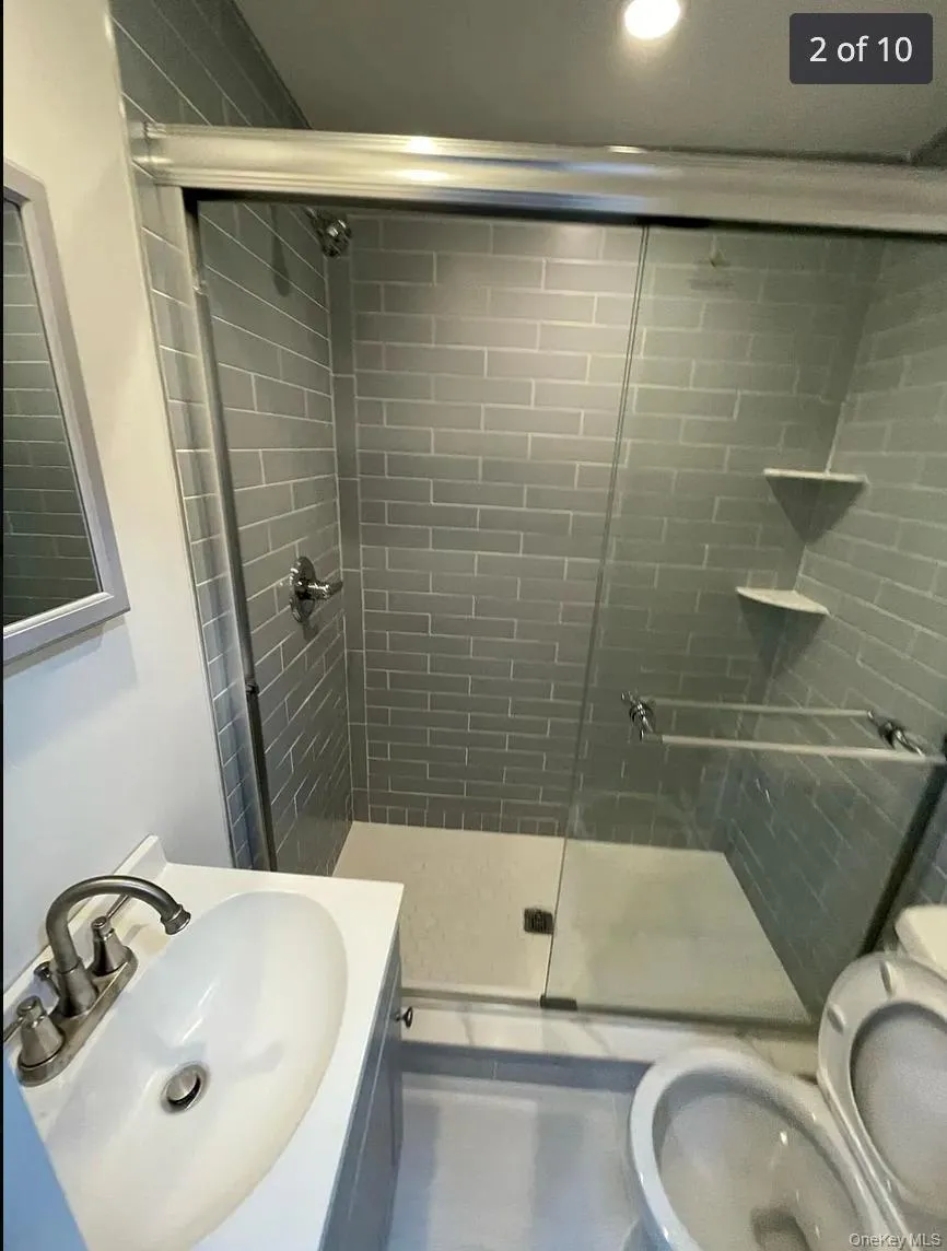 Full bath with a stall shower, vanity, and recessed lighting Full bath with a stall shower, vanity, and recessed lighting