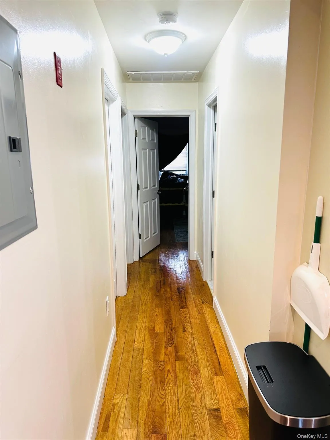 Hall featuring wood finished floors and electric panel Hall featuring wood finished floors and electric panel