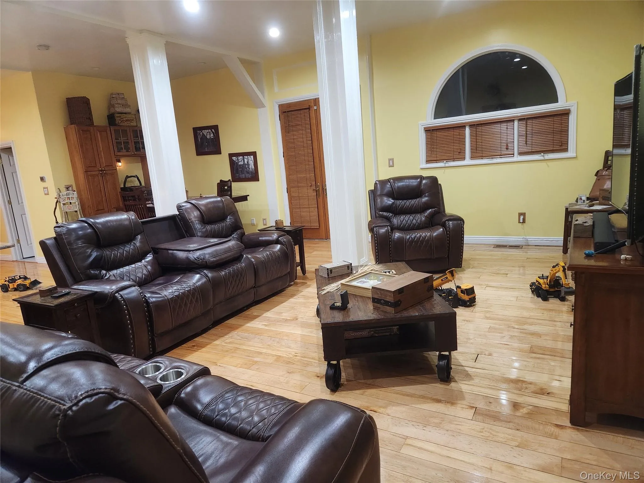 Living room with decorative columns and light hardwood / wood-style flooring Living room with decorative columns and light hardwood / wood-style flooring