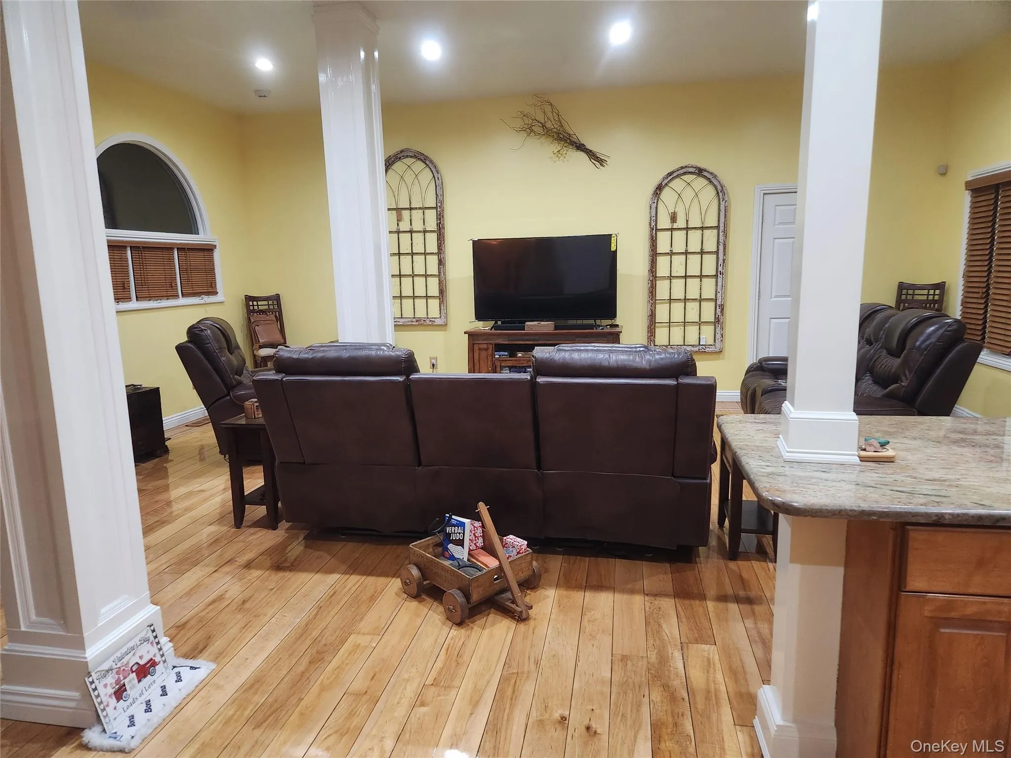 Living room featuring decorative columns and light hardwood / wood-style flooring Living room featuring decorative columns and light hardwood / wood-style flooring