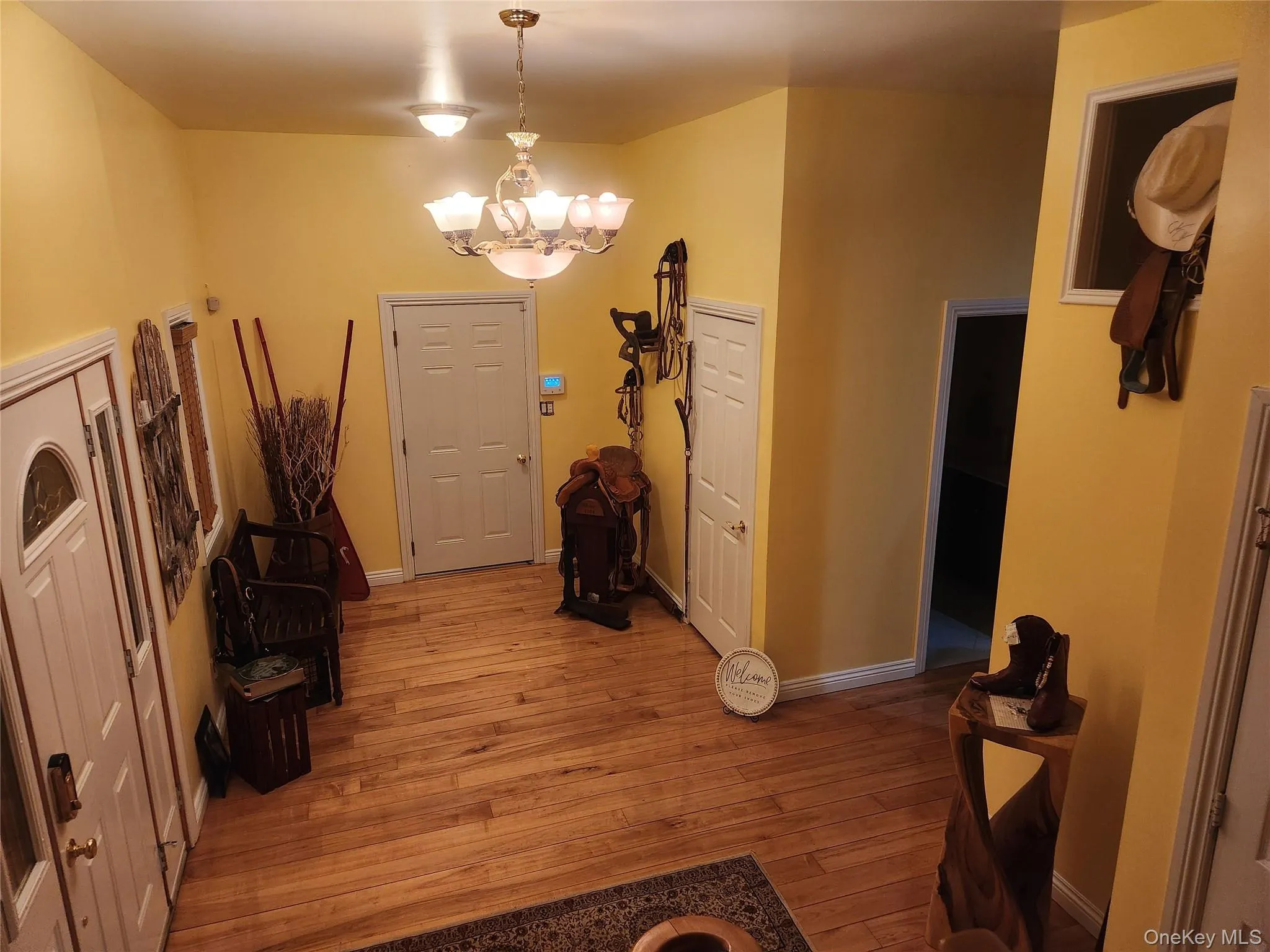 Entry foyer way with a notable chandelier and light hardwood / wood-style flooring Entry foyer way with a notable chandelier and light hardwood / wood-style flooring