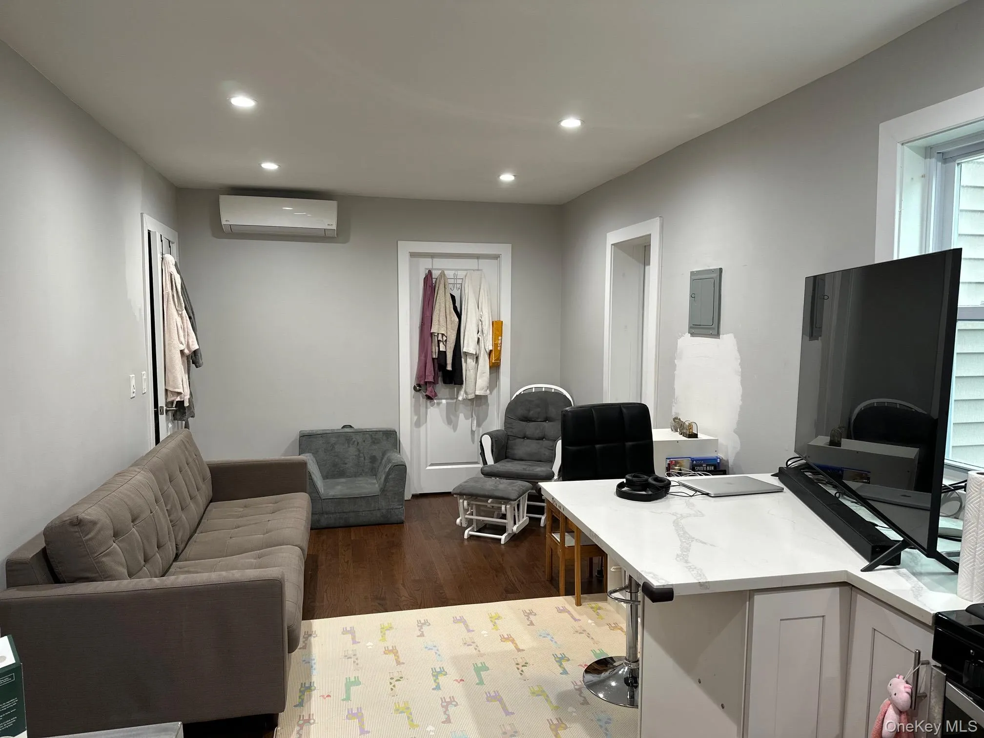 Office area featuring recessed lighting, dark wood-type flooring, electric panel, and a wall mounted AC Office area featuring recessed lighting, dark wood-type flooring, electric panel, and a wall mounted AC