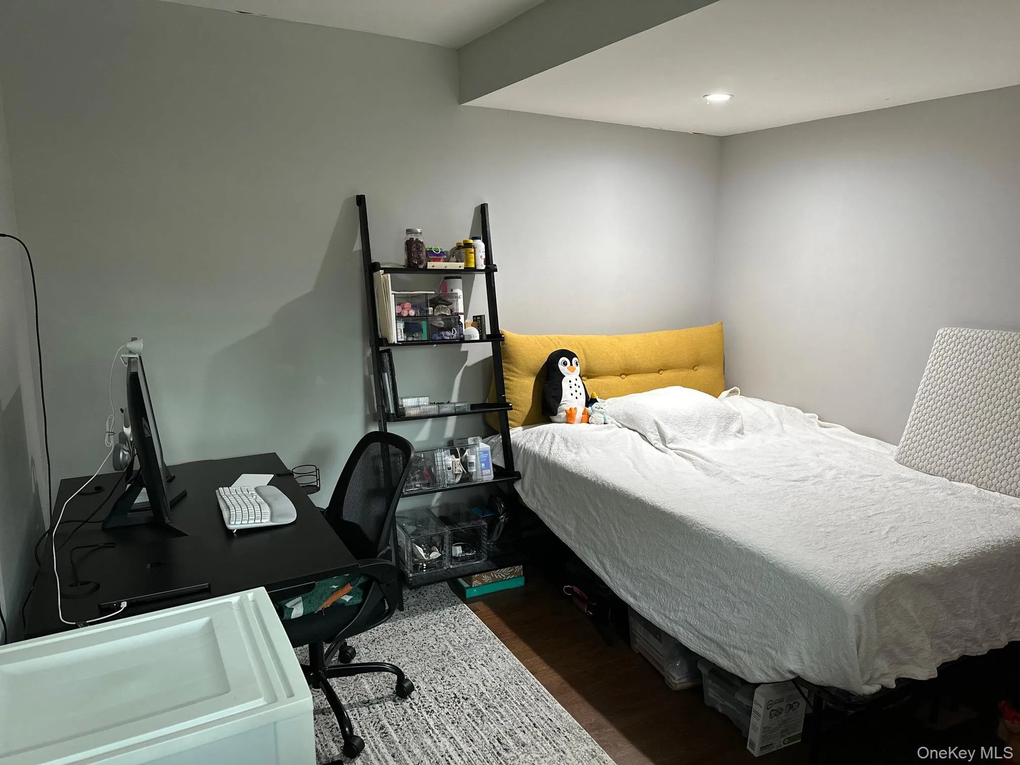 Bedroom with wood finished floors and an office area Bedroom with wood finished floors and an office area