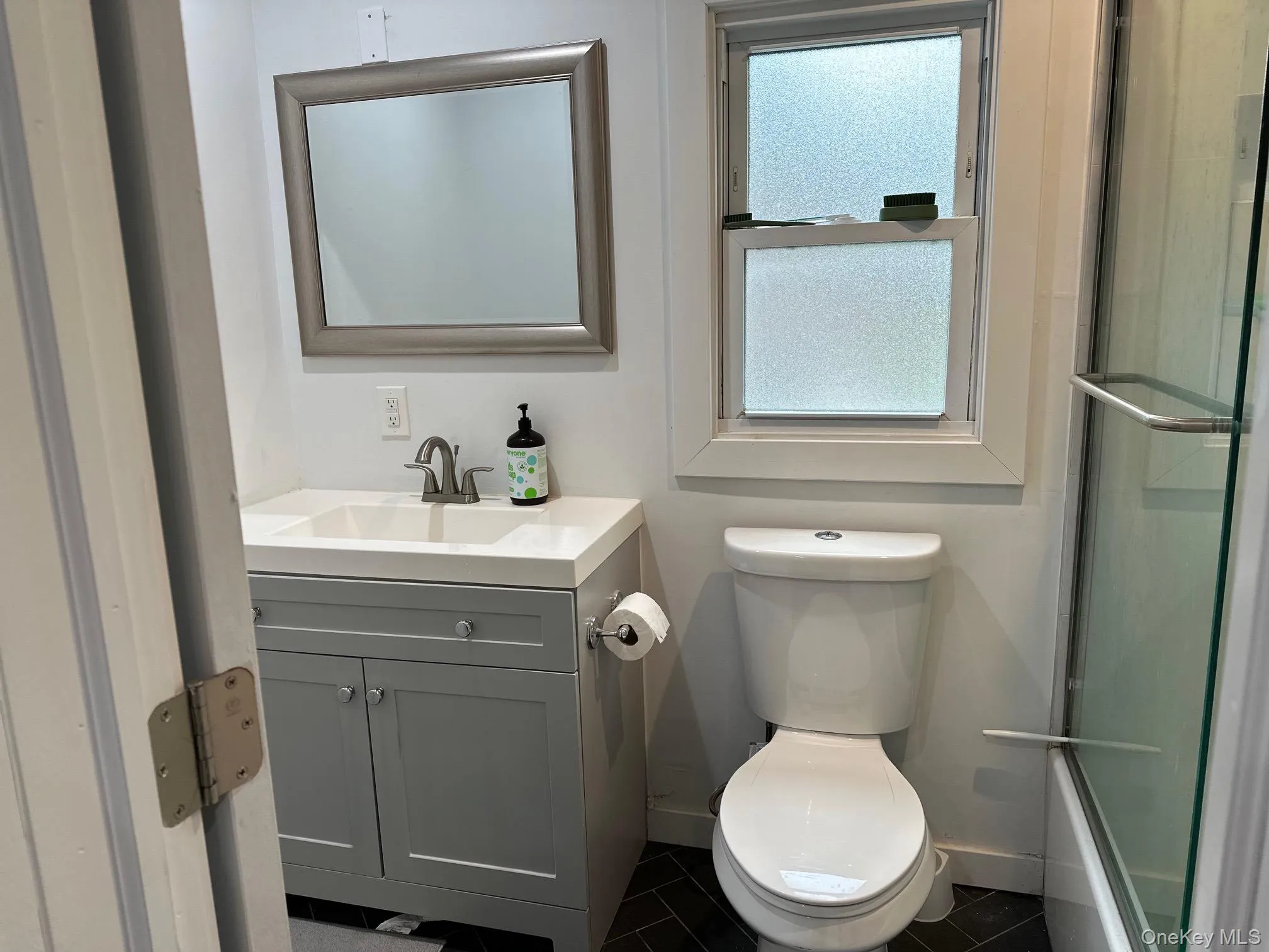 Full bathroom with vanity and dark tile patterned floors Full bathroom with vanity and dark tile patterned floors