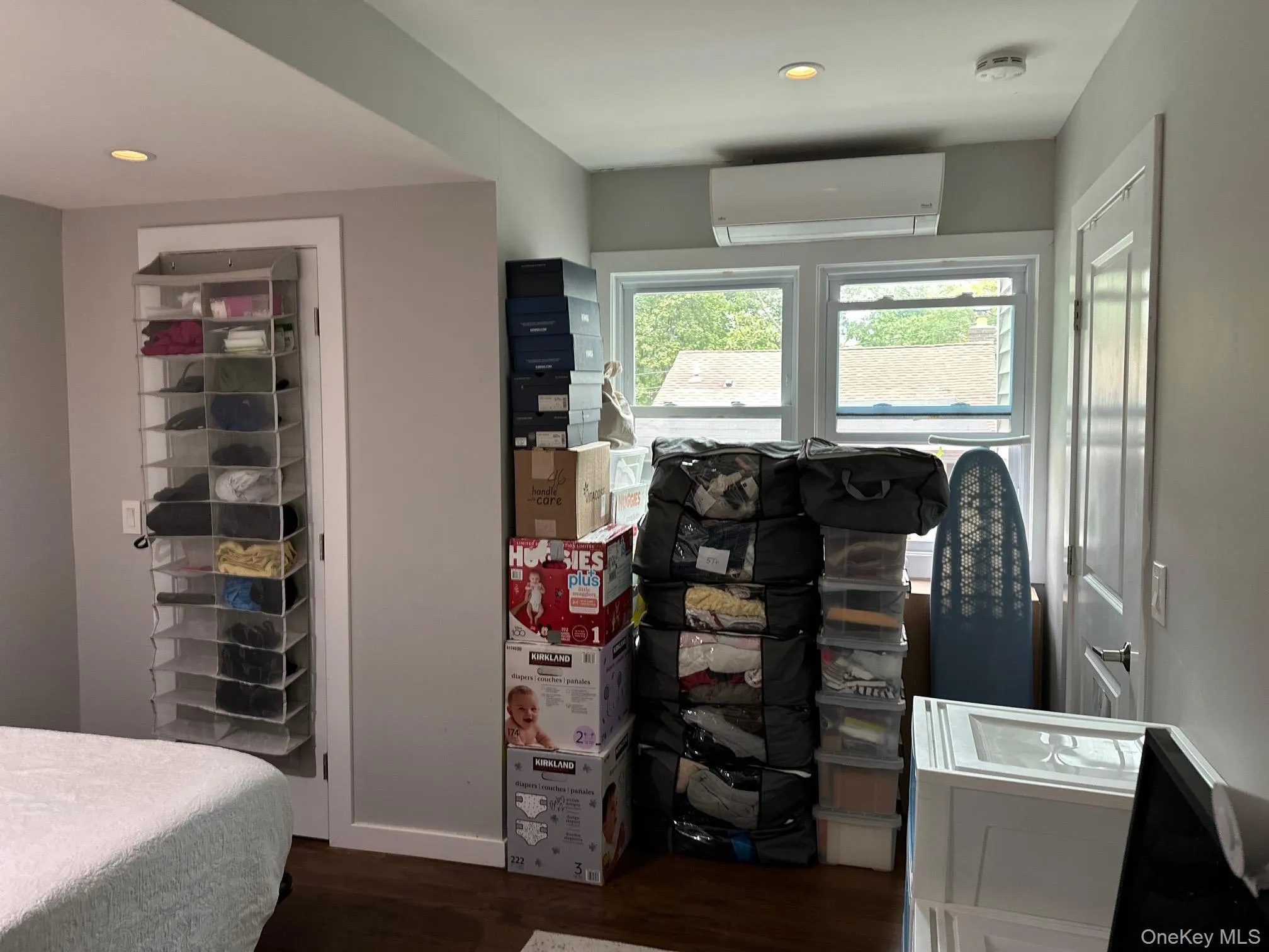 Bedroom featuring dark wood-style flooring, a wall unit AC, and recessed lighting Bedroom featuring dark wood-style flooring, a wall unit AC, and recessed lighting