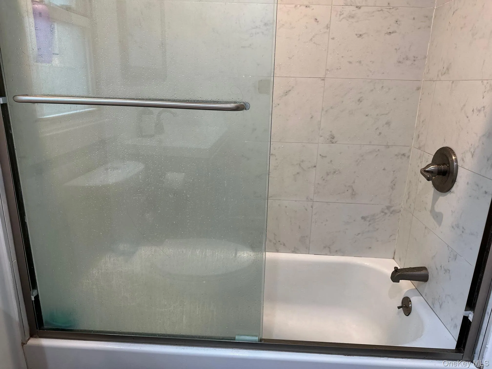 Bathroom with bath / shower combo with glass door Bathroom with bath / shower combo with glass door