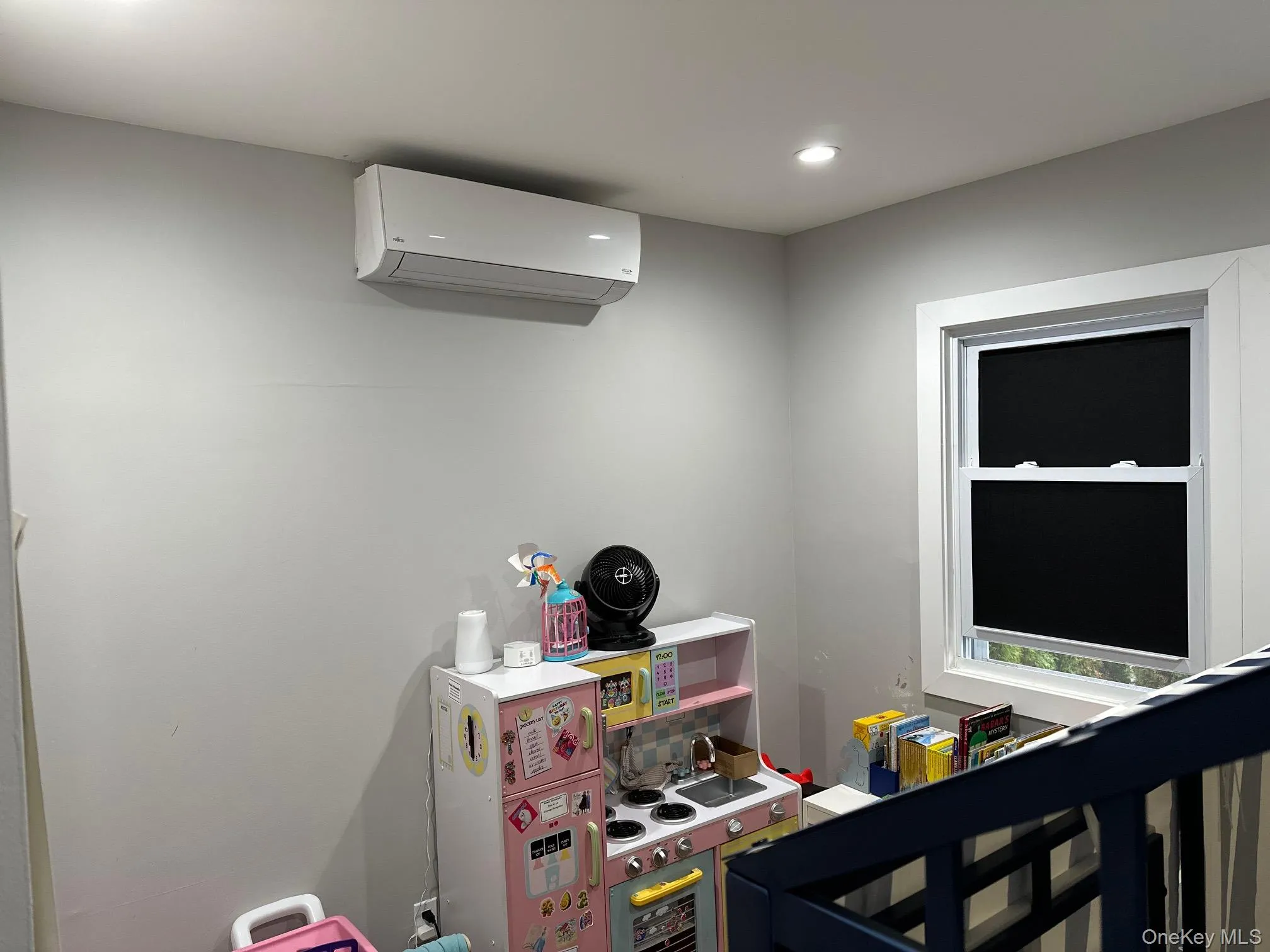 Bedroom with a wall mounted air conditioner and recessed lighting Bedroom with a wall mounted air conditioner and recessed lighting