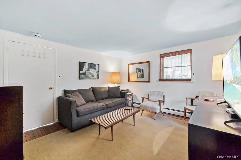Living area featuring a baseboard radiator and a desk Living area featuring a baseboard radiator and a desk
