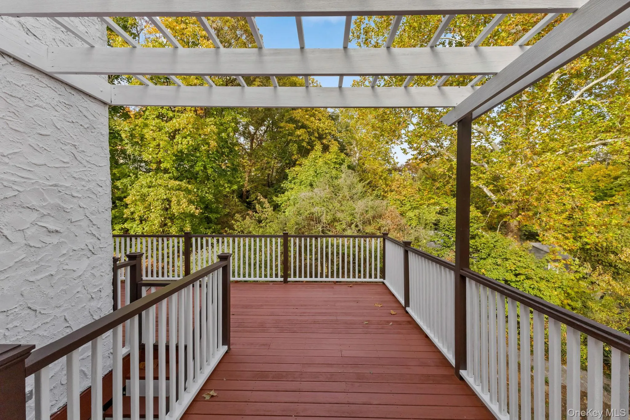 Wooden deck with a pergola and view of scattered trees Wooden deck with a pergola and view of scattered trees