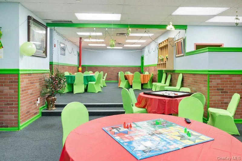 Rec room featuring a drop ceiling, brick wall, and a wainscoted wall Rec room featuring a drop ceiling, brick wall, and a wainscoted wall