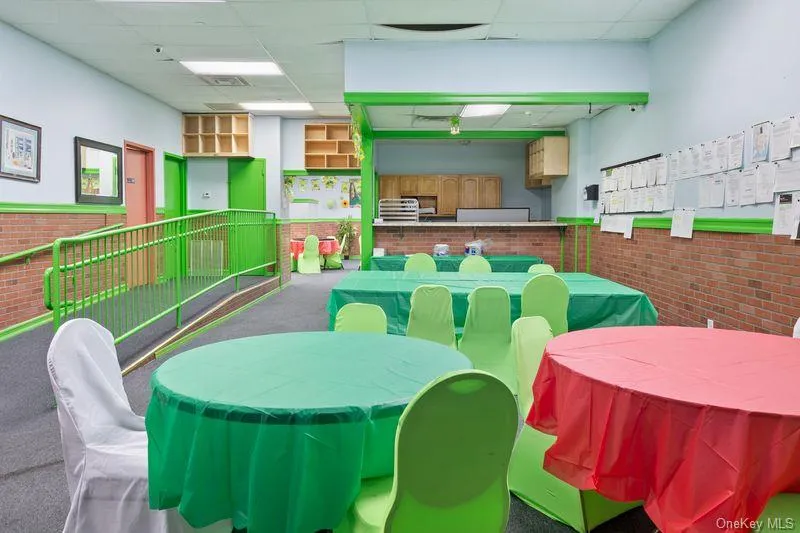 Rec room with wainscoting, a drop ceiling, and brick wall Rec room with wainscoting, a drop ceiling, and brick wall