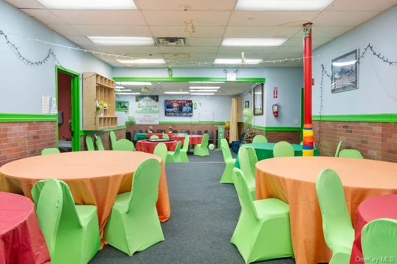 Rec room with wainscoting, a drop ceiling, and brick wall Rec room with wainscoting, a drop ceiling, and brick wall