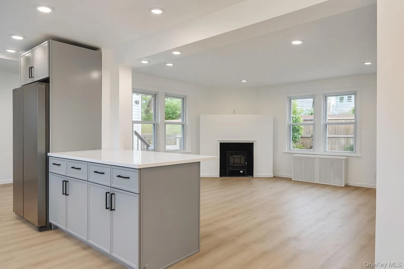 Kitchen with gray cabinetry, recessed lighting, freestanding refrigerator, radiator heating unit, and plenty of natural light Kitchen with gray cabinetry, recessed lighting, freestanding refrigerator, radiator heating unit, and plenty of natural light