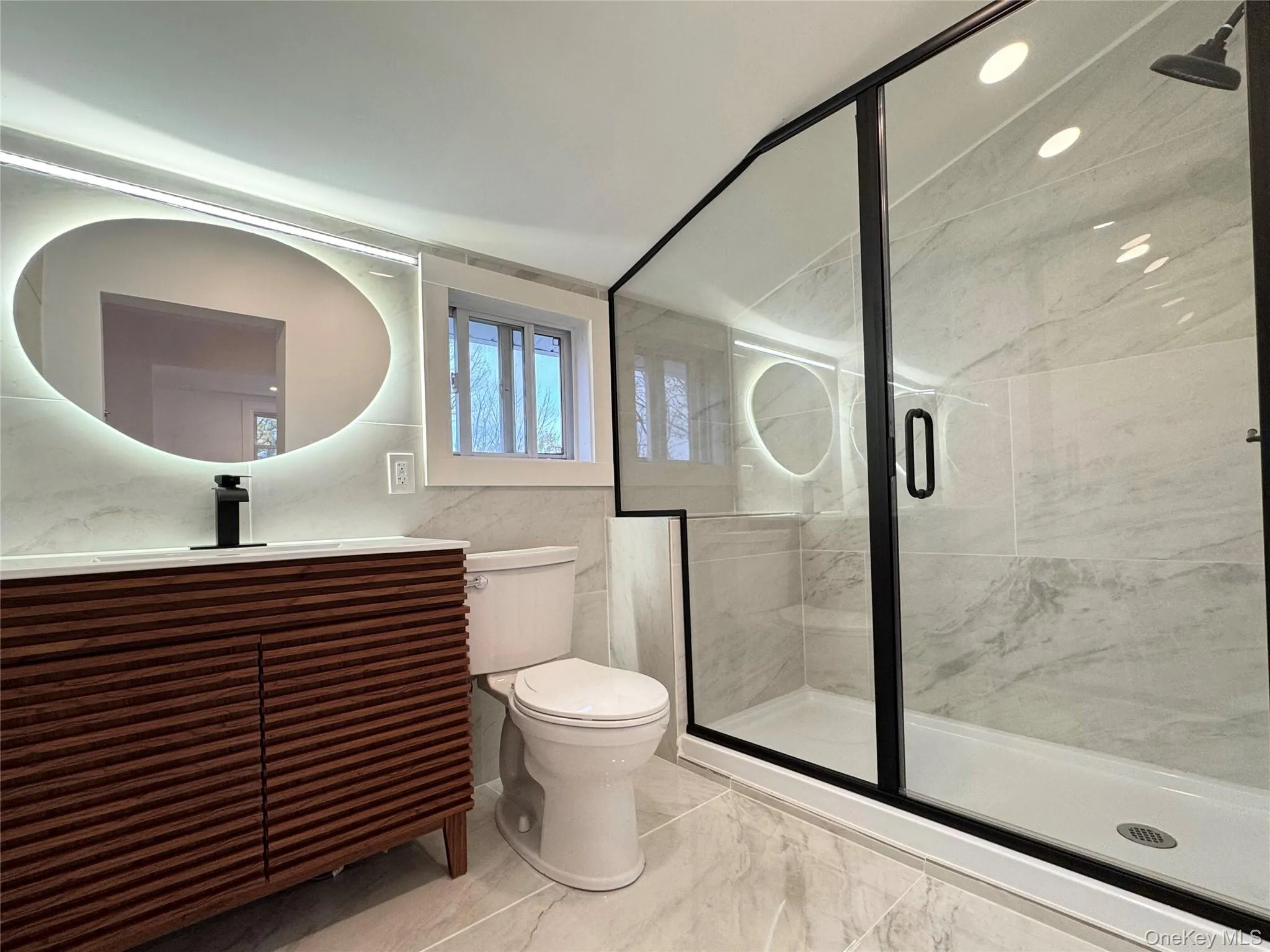 Full bathroom featuring a shower stall, vanity, and tile walls Full bathroom featuring a shower stall, vanity, and tile walls
