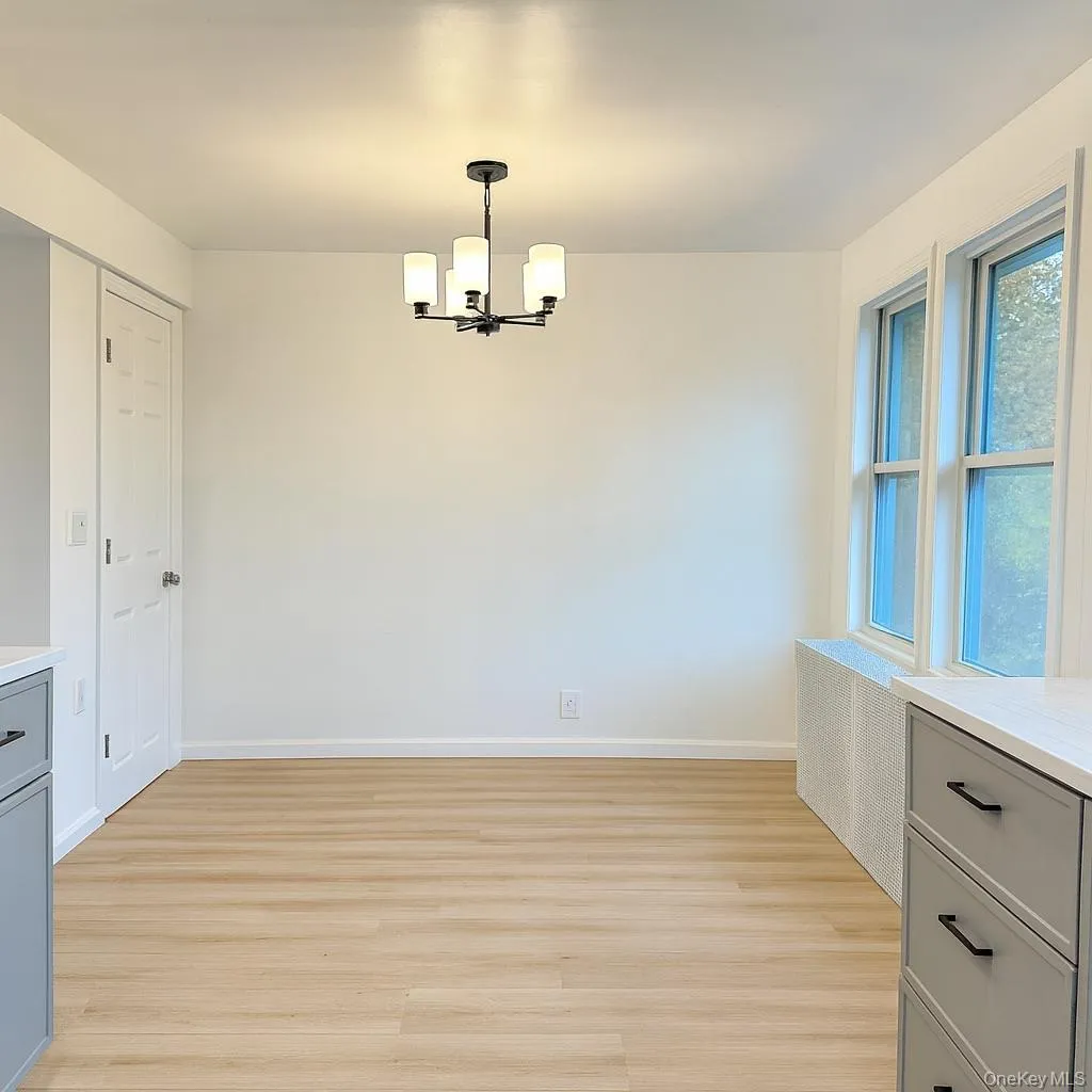 Unfurnished dining area with light wood finished floors and a chandelier Unfurnished dining area with light wood finished floors and a chandelier