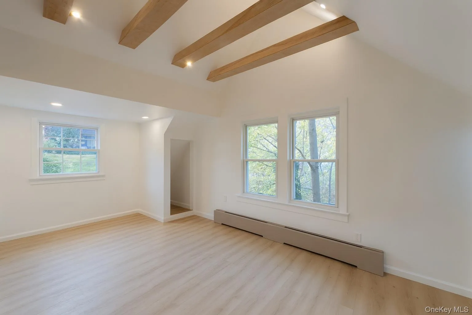 Top level bedroom featuring beamed ceiling, a baseboard radiator, light wood finished floors, and recessed lighting Top level bedroom featuring beamed ceiling, a baseboard radiator, light wood finished floors, and recessed lighting