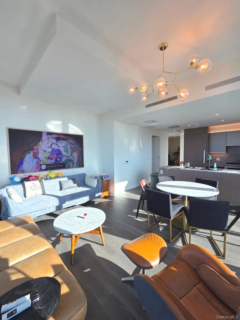 Living room with dark wood-style flooring and a chandelier Living room with dark wood-style flooring and a chandelier