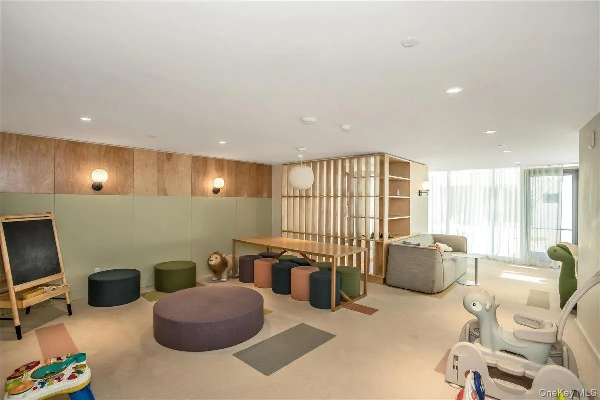 Recreation room with carpet flooring, wooden walls, recessed lighting, and floor to ceiling windows Recreation room with carpet flooring, wooden walls, recessed lighting, and floor to ceiling windows