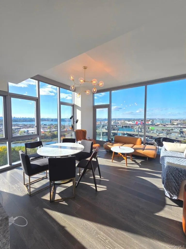 Dining space featuring expansive windows, dark wood finished floors, a chandelier, and a view of city Dining space featuring expansive windows, dark wood finished floors, a chandelier, and a view of city