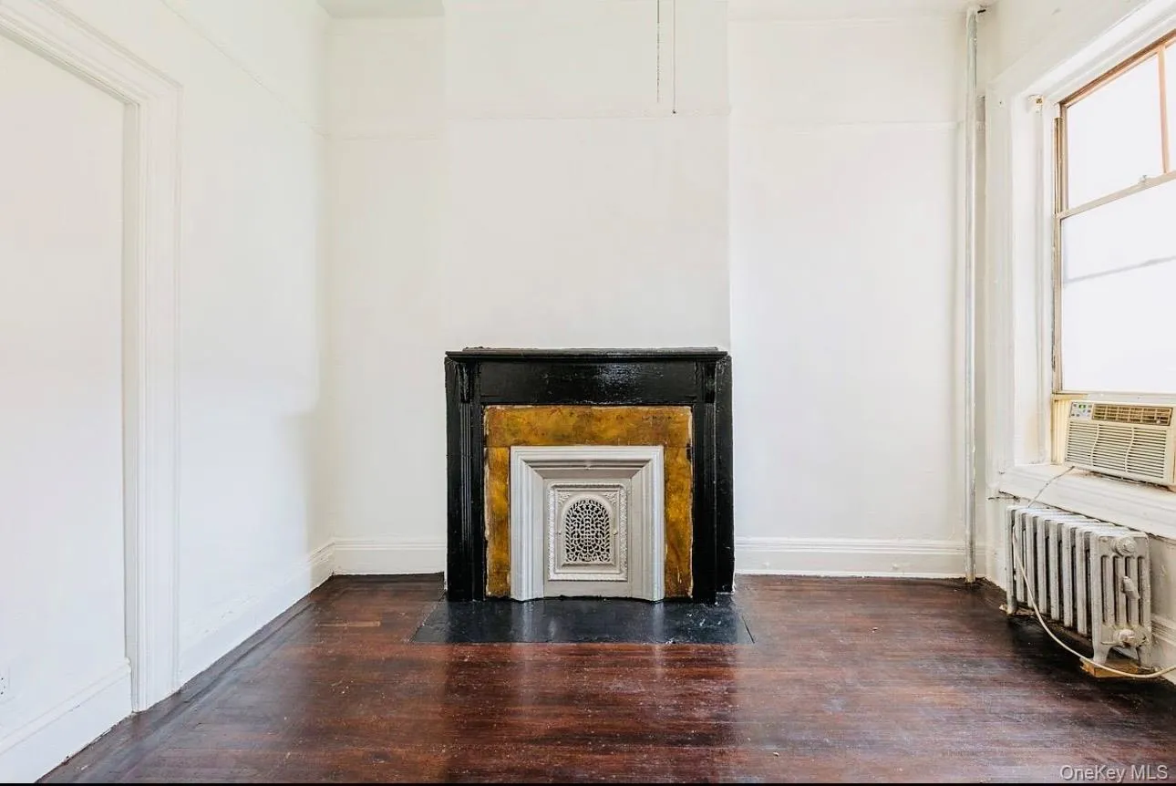 Detailed view of wood finished floors, radiator, and cooling unit Detailed view of wood finished floors, radiator, and cooling unit