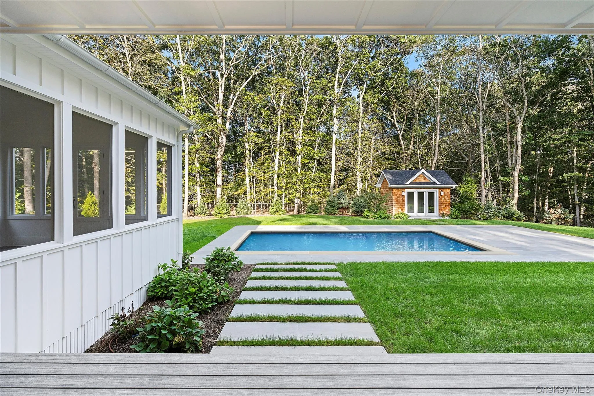 Pool with pool house, privacy with scattered trees, and landscaping, and lawn Pool with pool house, privacy with scattered trees, and landscaping, and lawn