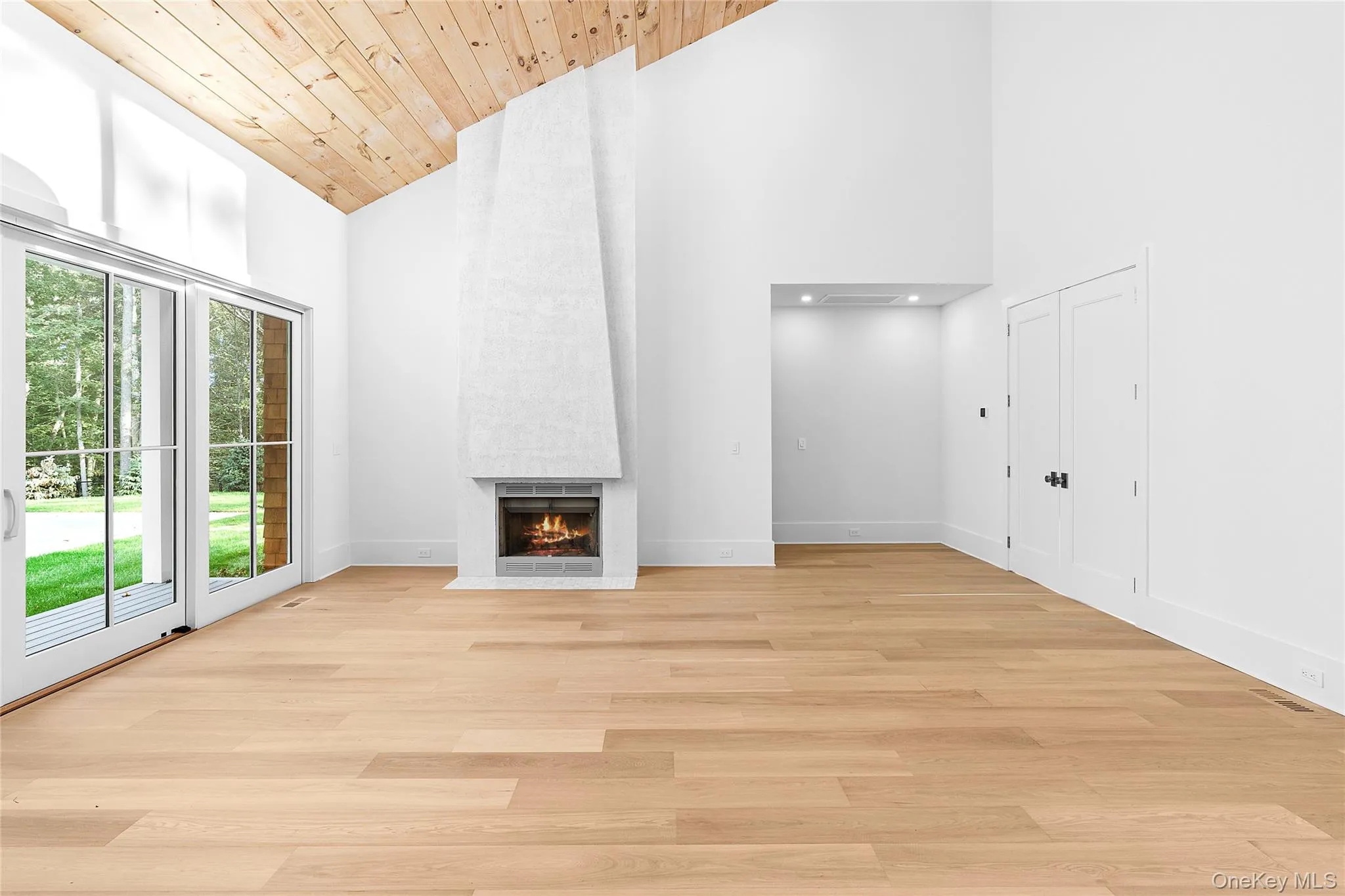 Unfurnished living room with high vaulted ceiling, a fireplace, light wood finished floors, and wooden ceiling Unfurnished living room with high vaulted ceiling, a fireplace, light wood finished floors, and wooden ceiling