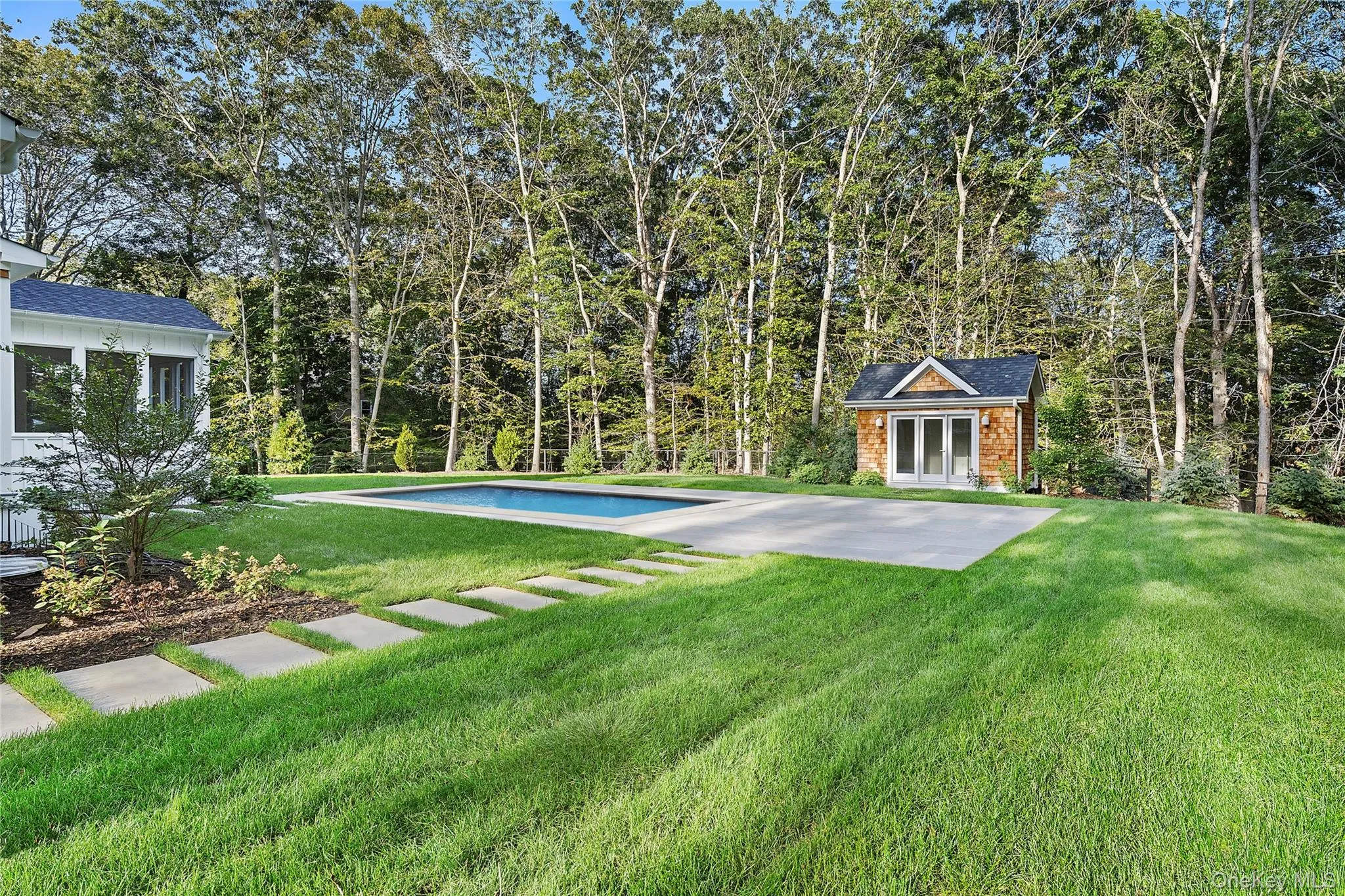 Outdoor pool with a pool house and a yard Outdoor pool with a pool house and a yard