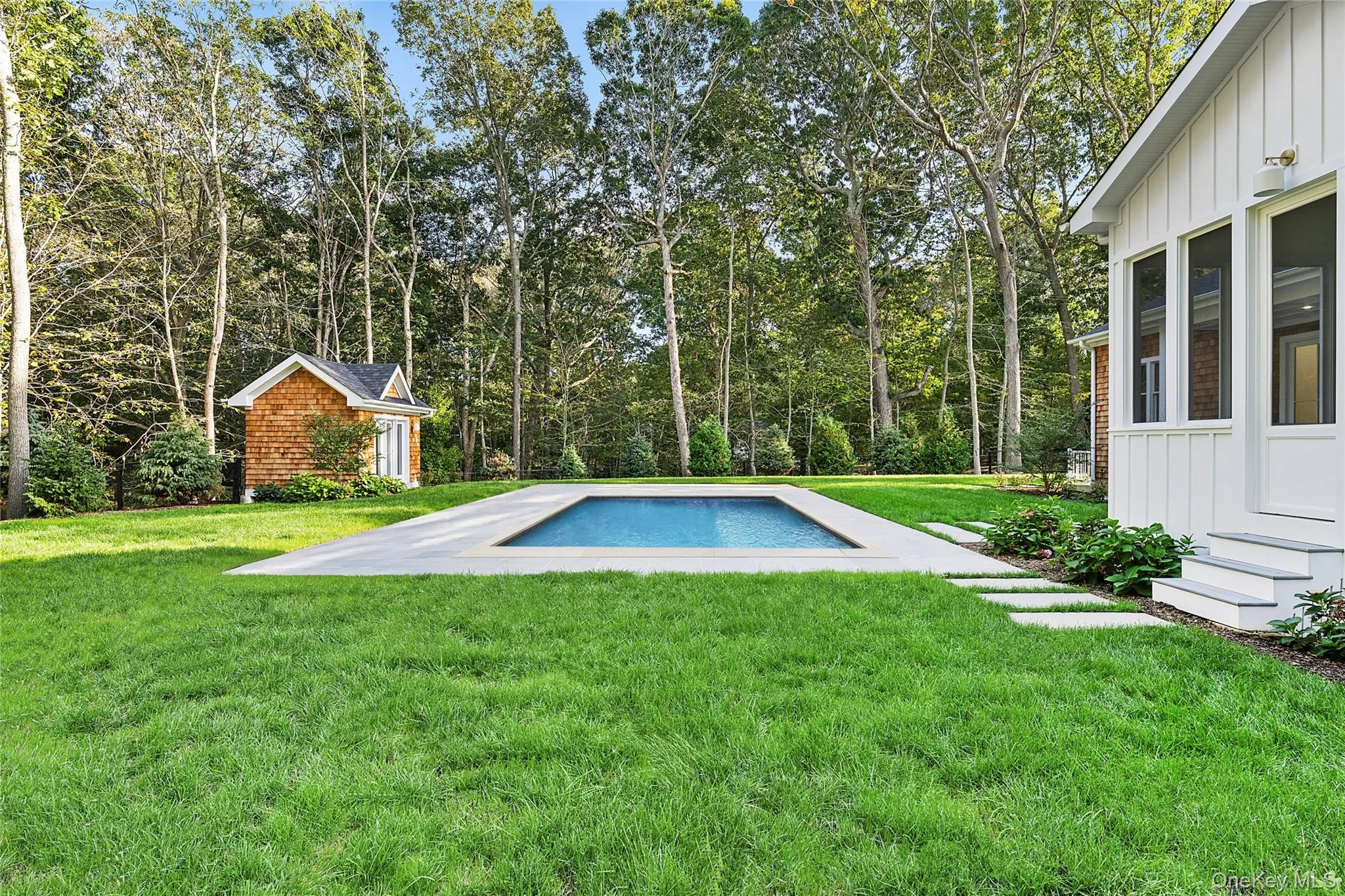 Outdoor pool with a pool house and a yard Outdoor pool with a pool house and a yard