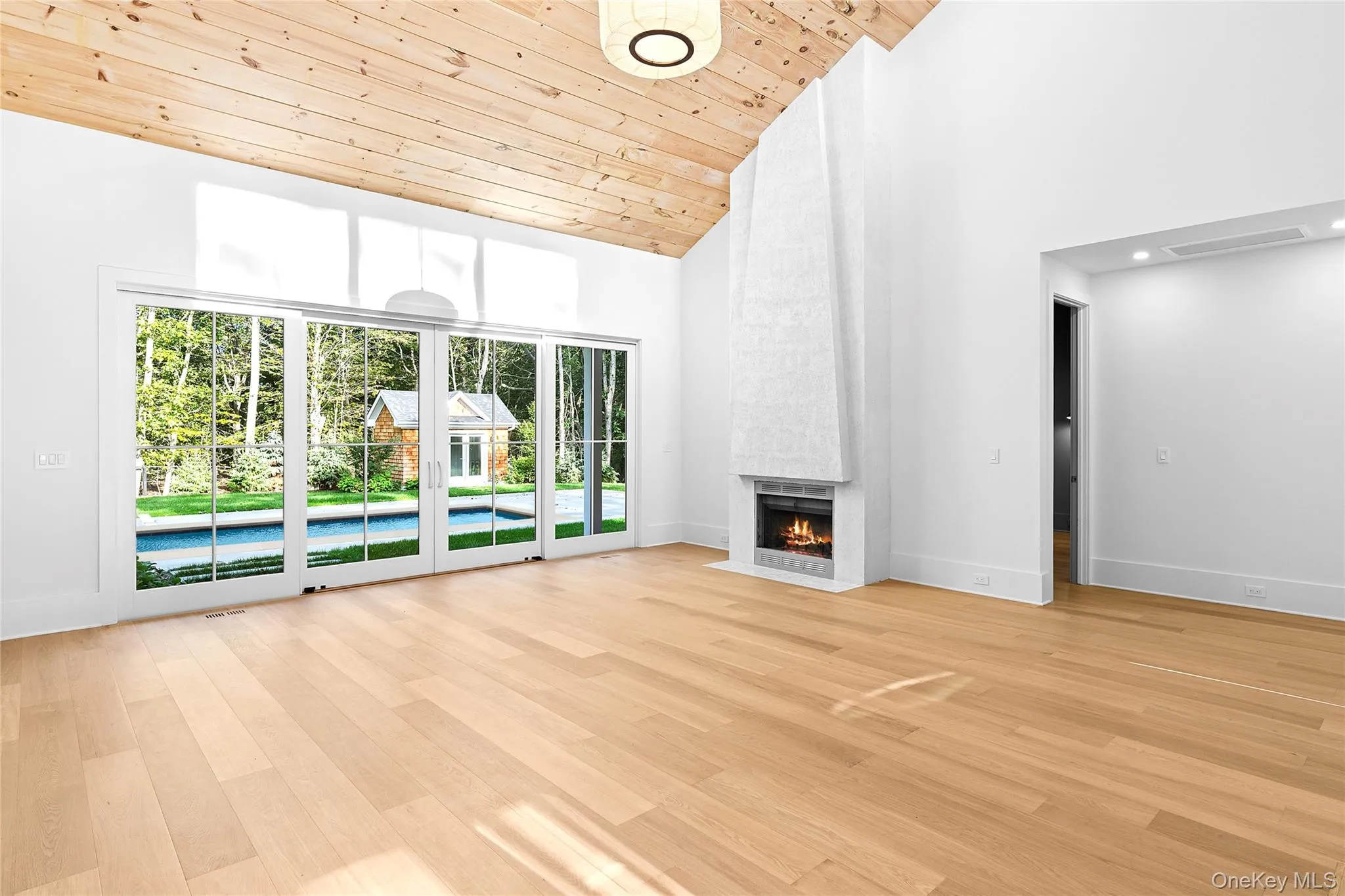 Unfurnished living room with high vaulted ceiling, light wood-style flooring, wooden ceiling, and a fireplace Unfurnished living room with high vaulted ceiling, light wood-style flooring, wooden ceiling, and a fireplace