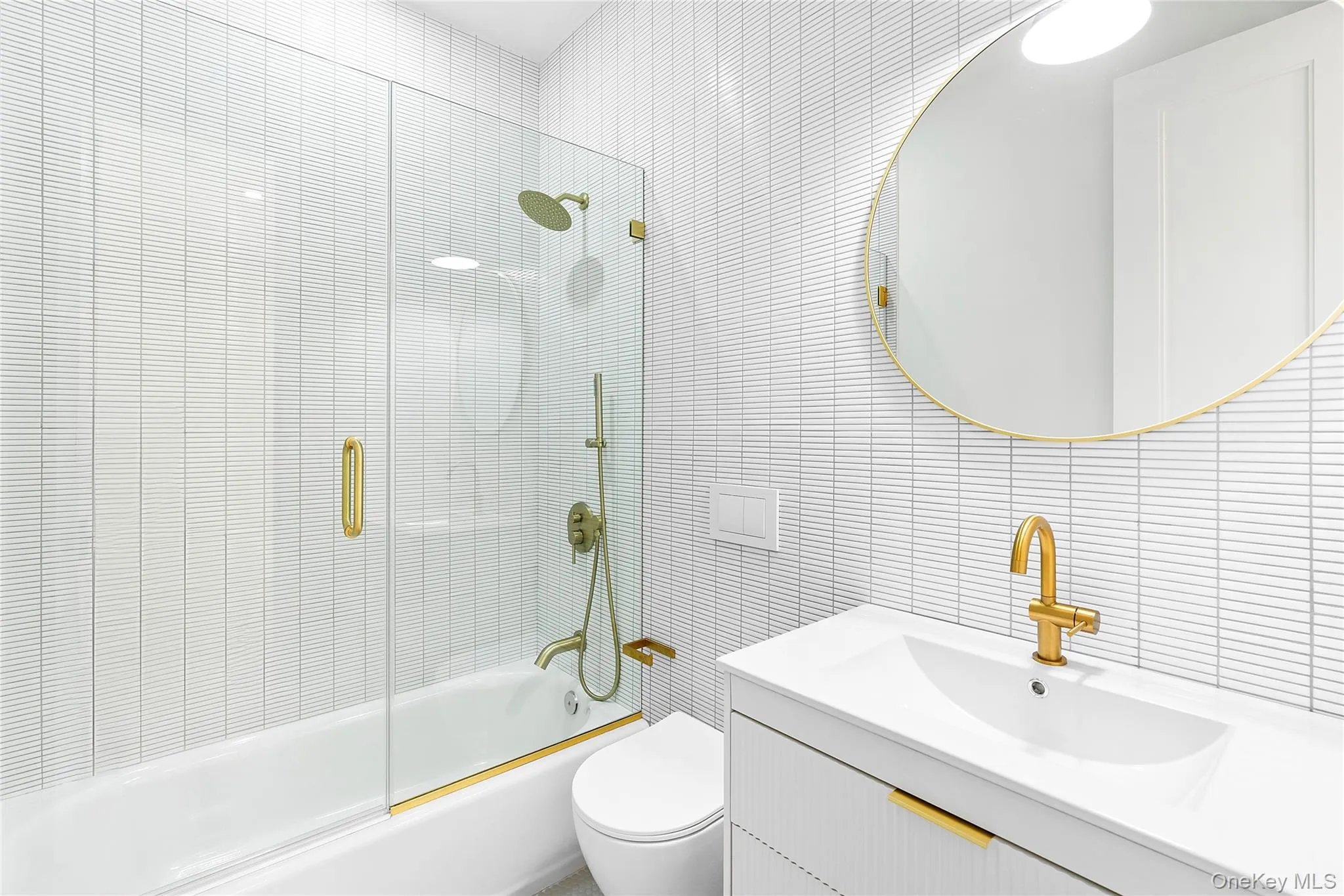 Bathroom with tile walls, combined bath / shower with glass door, and vanity Bathroom with tile walls, combined bath / shower with glass door, and vanity
