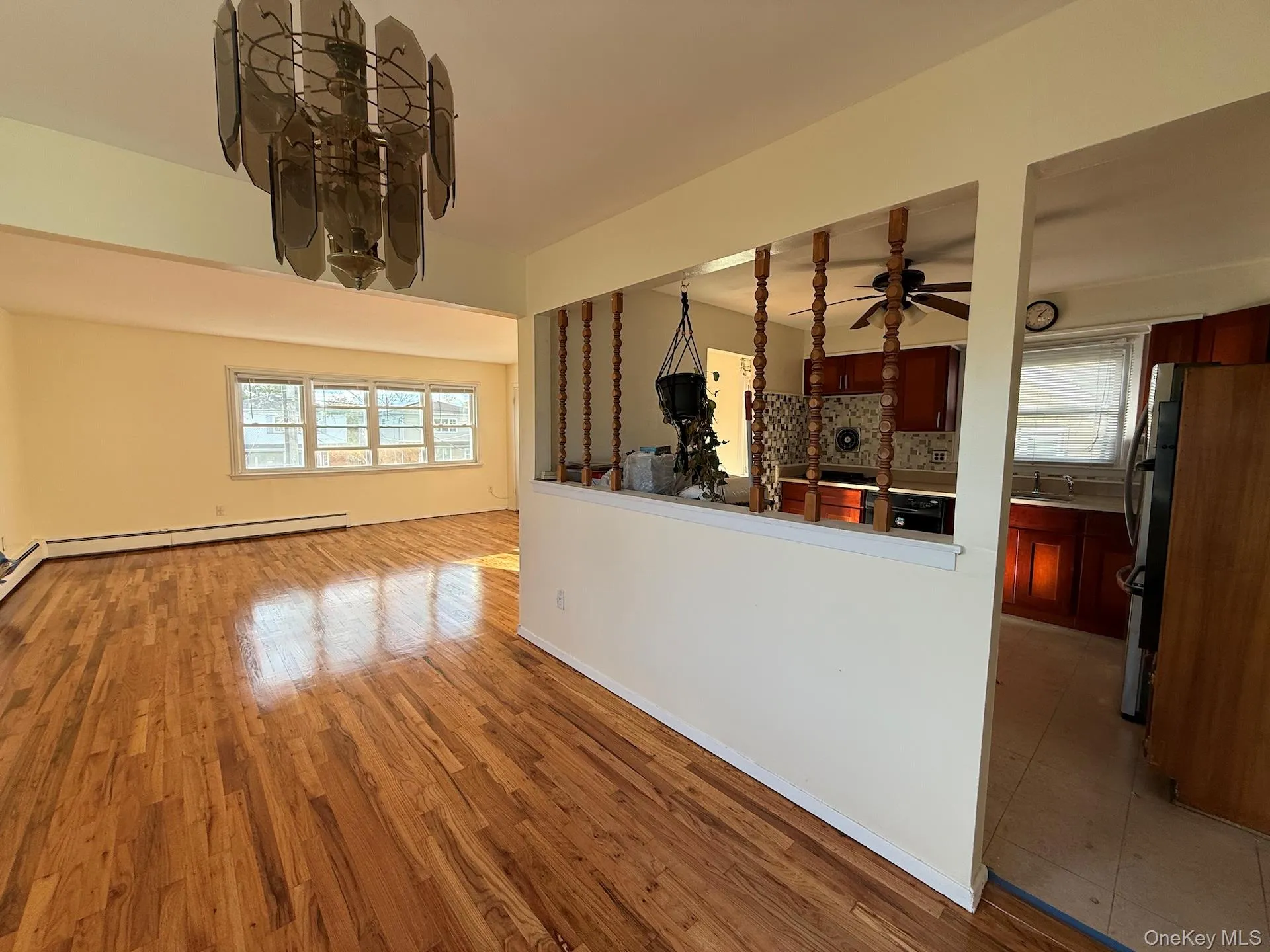 Spare room with plenty of natural light, light wood-style floors, and a baseboard heating unit Spare room with plenty of natural light, light wood-style floors, and a baseboard heating unit