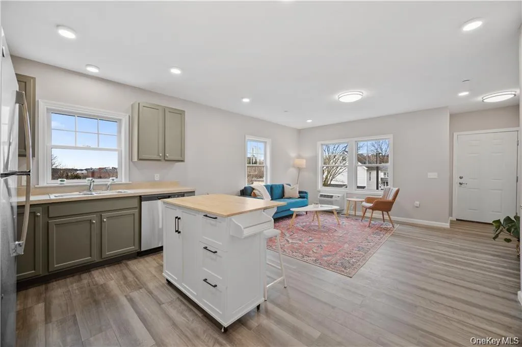 Kitchen featuring a kitchen breakfast bar, stainless steel appliances, light wood-style flooring, open floor plan, and recessed lighting Kitchen featuring a kitchen breakfast bar, stainless steel appliances, light wood-style flooring, open floor plan, and recessed lighting