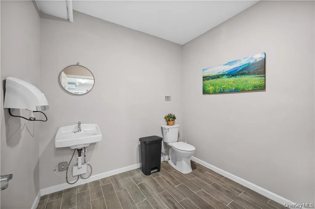 Half bathroom featuring baseboards and wood tiled floors Half bathroom featuring baseboards and wood tiled floors