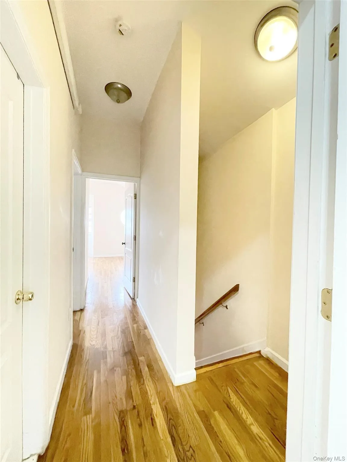 Hall featuring an upstairs landing and light wood-type flooring Hall featuring an upstairs landing and light wood-type flooring