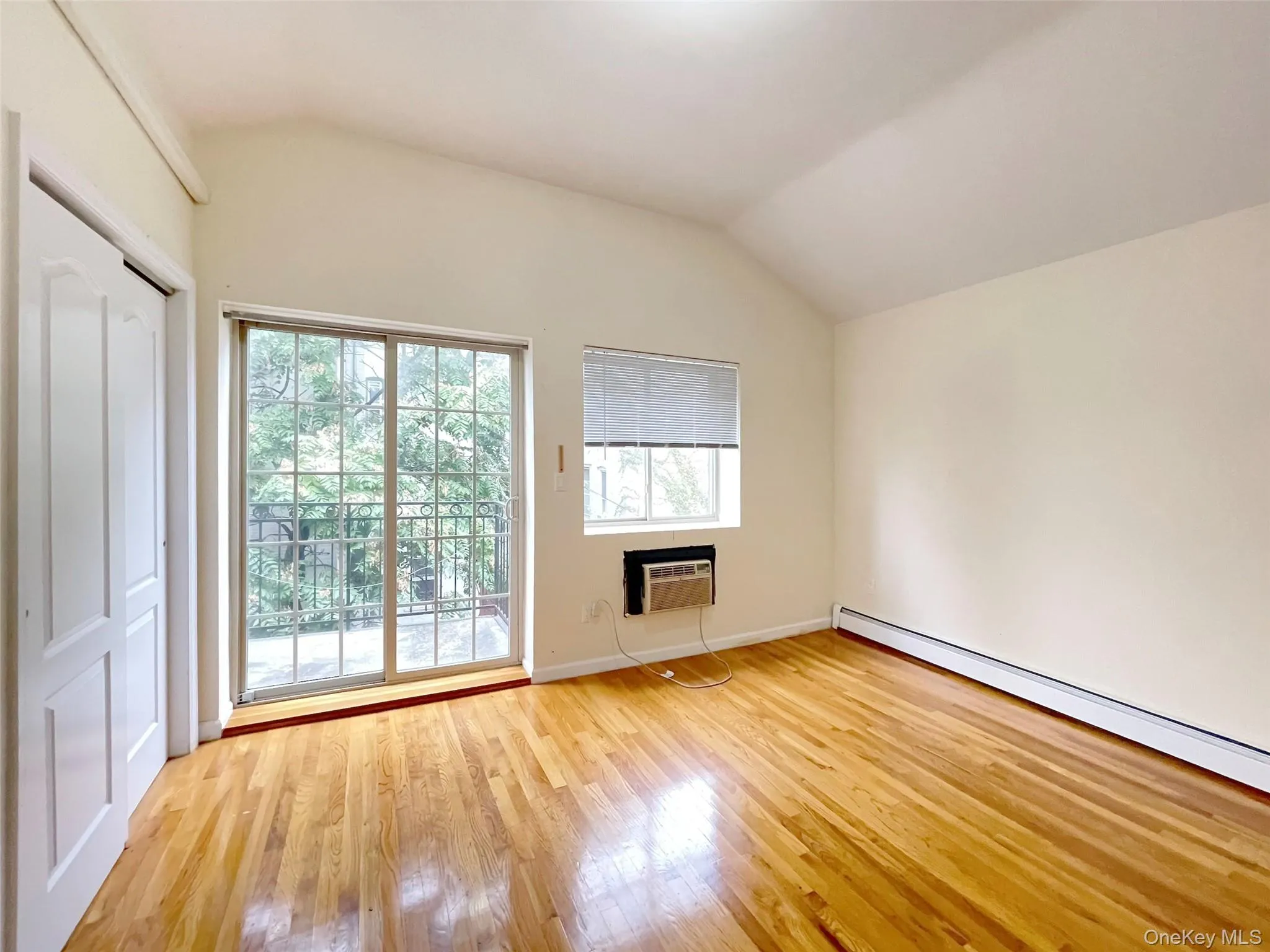 Unfurnished living room with lofted ceiling and light wood-type flooring Unfurnished living room with lofted ceiling and light wood-type flooring