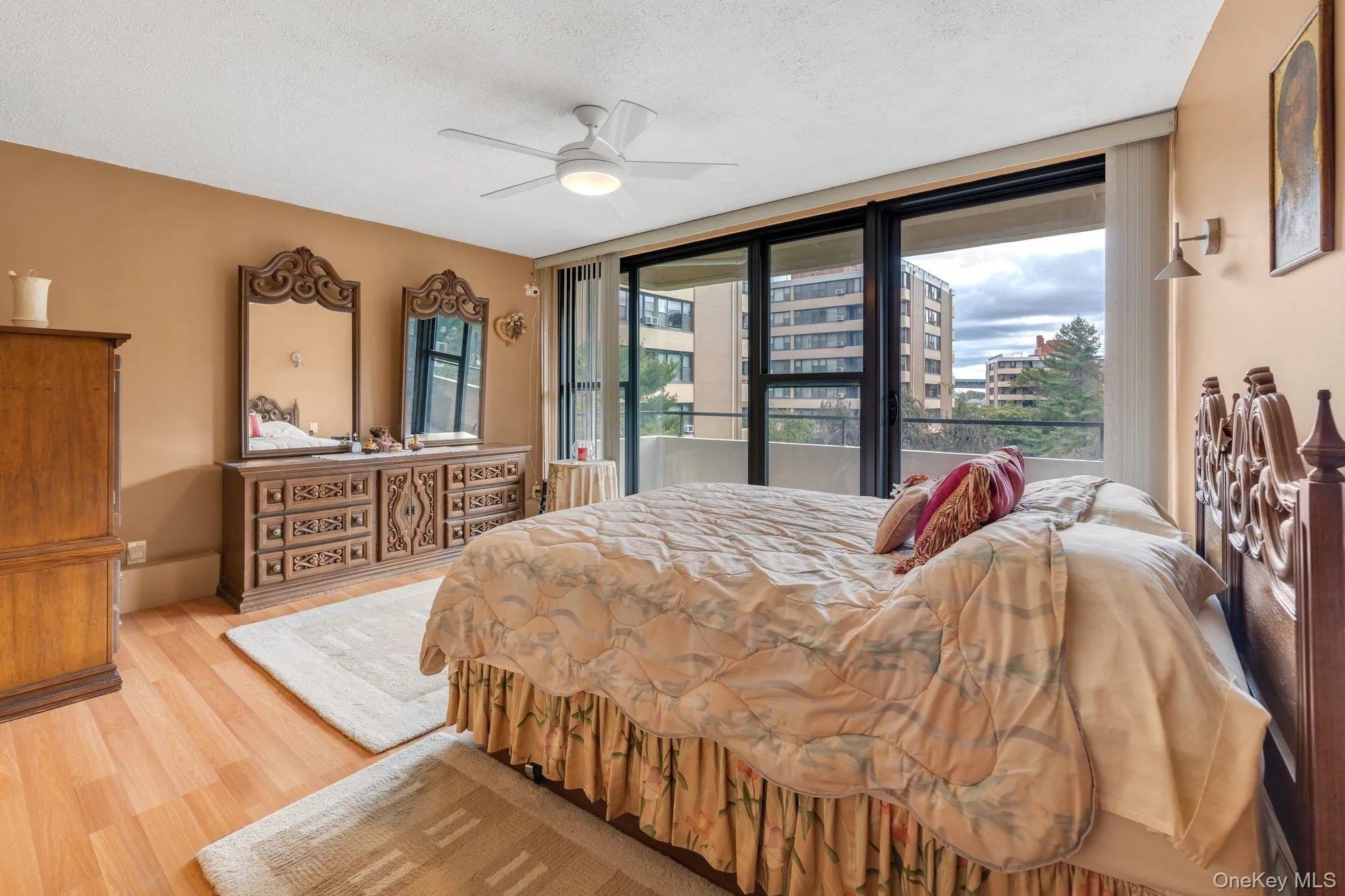 Bedroom featuring light wood finished floors, a textured ceiling, and ceiling fan Bedroom featuring light wood finished floors, a textured ceiling, and ceiling fan