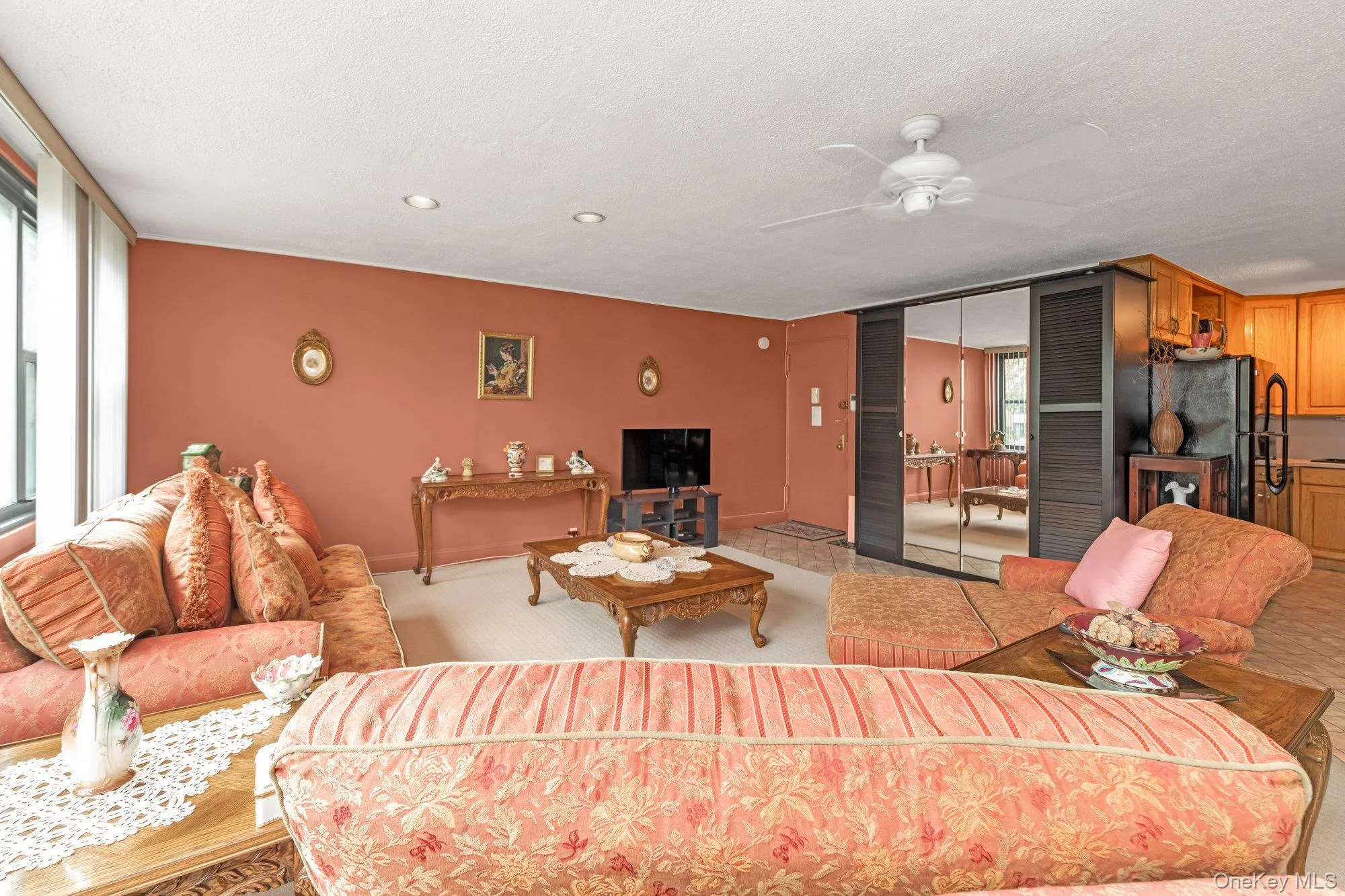 Carpeted living area with a textured ceiling and ceiling fan Carpeted living area with a textured ceiling and ceiling fan