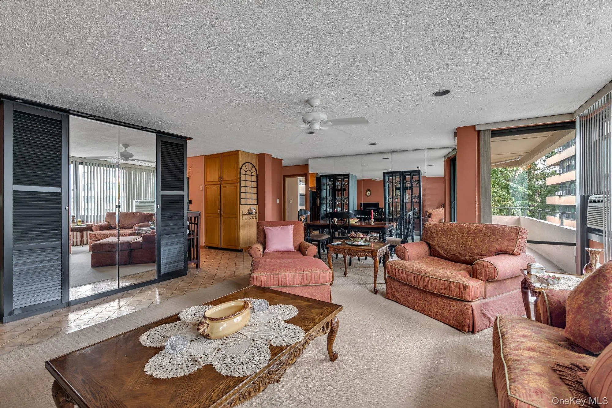 Living room with a textured ceiling, carpet flooring, and ceiling fan Living room with a textured ceiling, carpet flooring, and ceiling fan