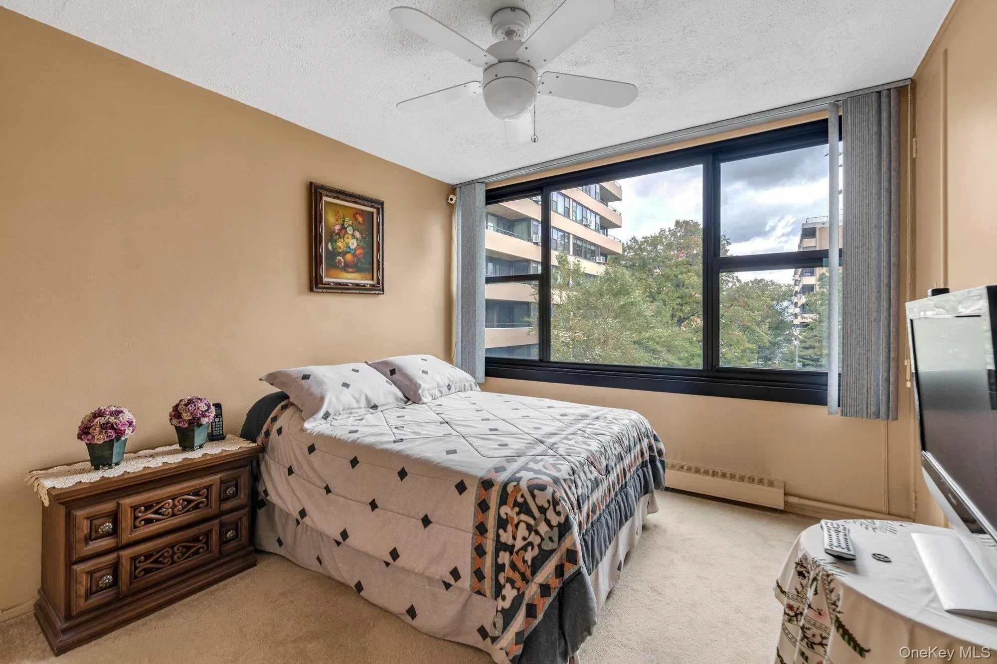 Bedroom with light carpet, a textured ceiling, baseboard heating, and ceiling fan Bedroom with light carpet, a textured ceiling, baseboard heating, and ceiling fan