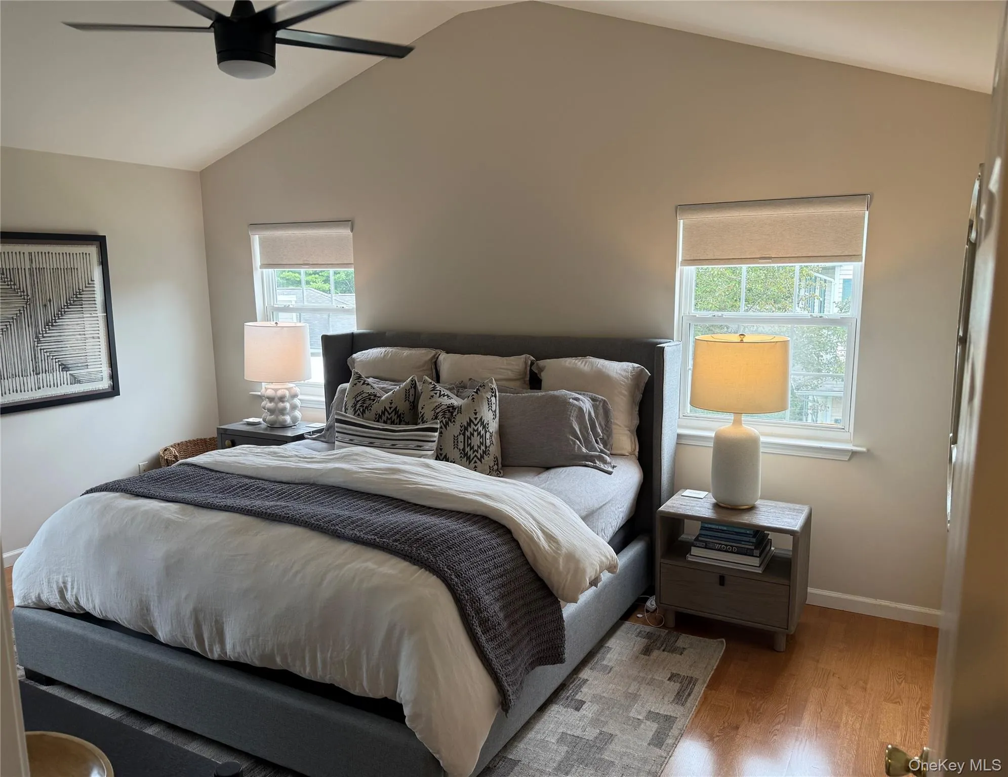 Bedroom with wood finished floors, vaulted ceiling, and ceiling fan Bedroom with wood finished floors, vaulted ceiling, and ceiling fan