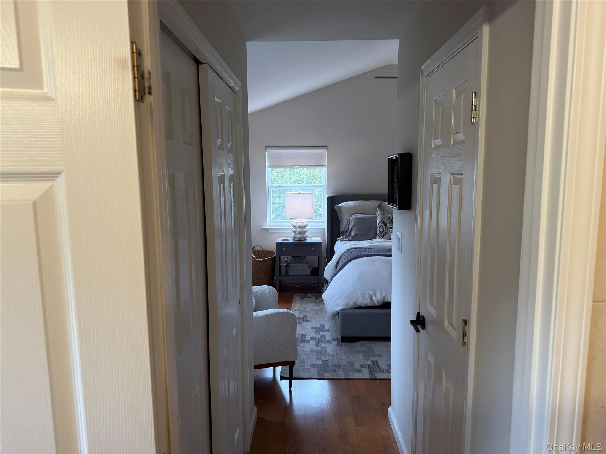 Hall featuring vaulted ceiling and dark wood-style flooring Hall featuring vaulted ceiling and dark wood-style flooring