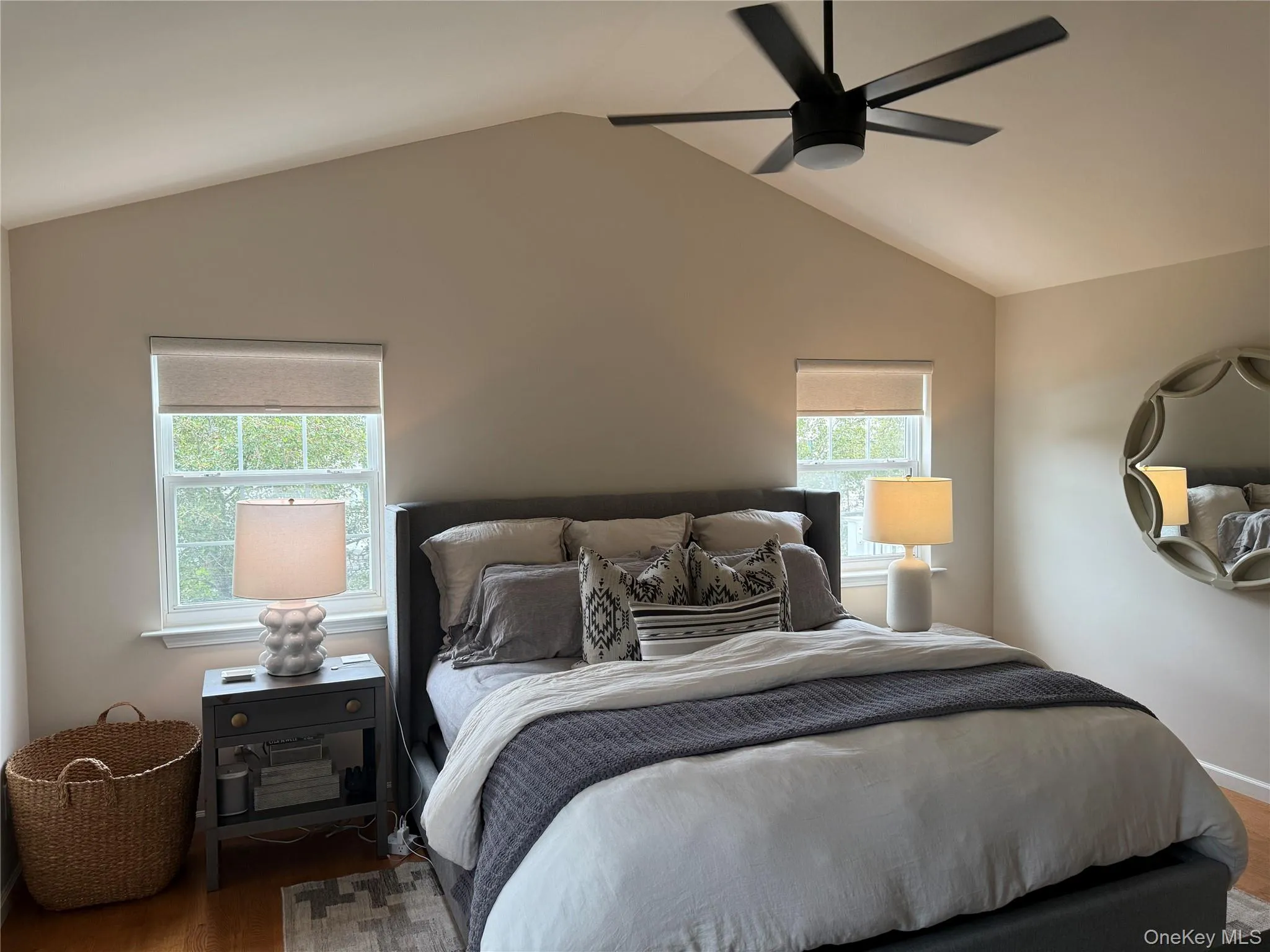 Bedroom featuring wood finished floors, vaulted ceiling, and ceiling fan Bedroom featuring wood finished floors, vaulted ceiling, and ceiling fan