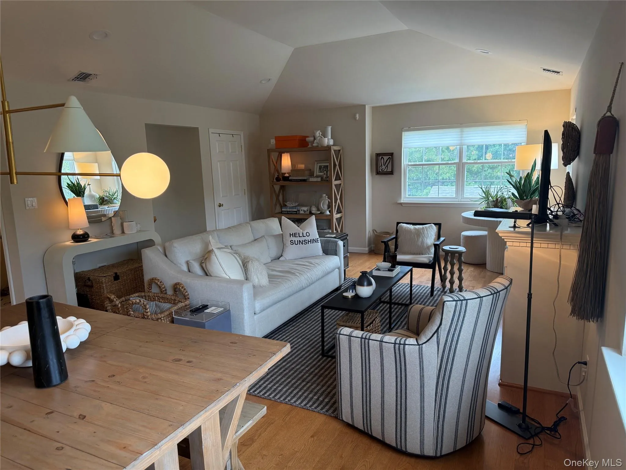 Living room featuring wood finished floors and vaulted ceiling Living room featuring wood finished floors and vaulted ceiling