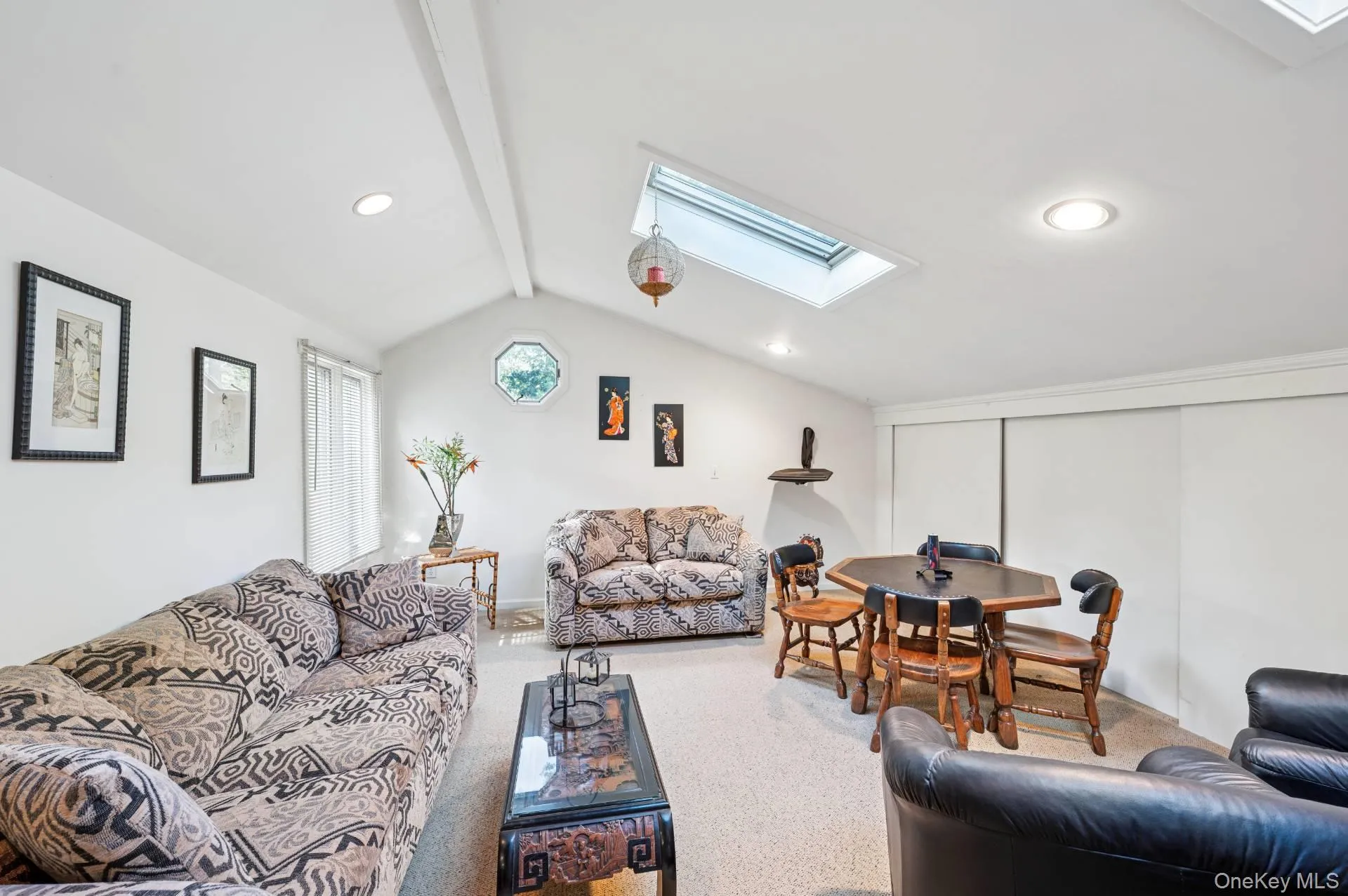 Living room featuring a skylight, carpet, and recessed lighting Living room featuring a skylight, carpet, and recessed lighting