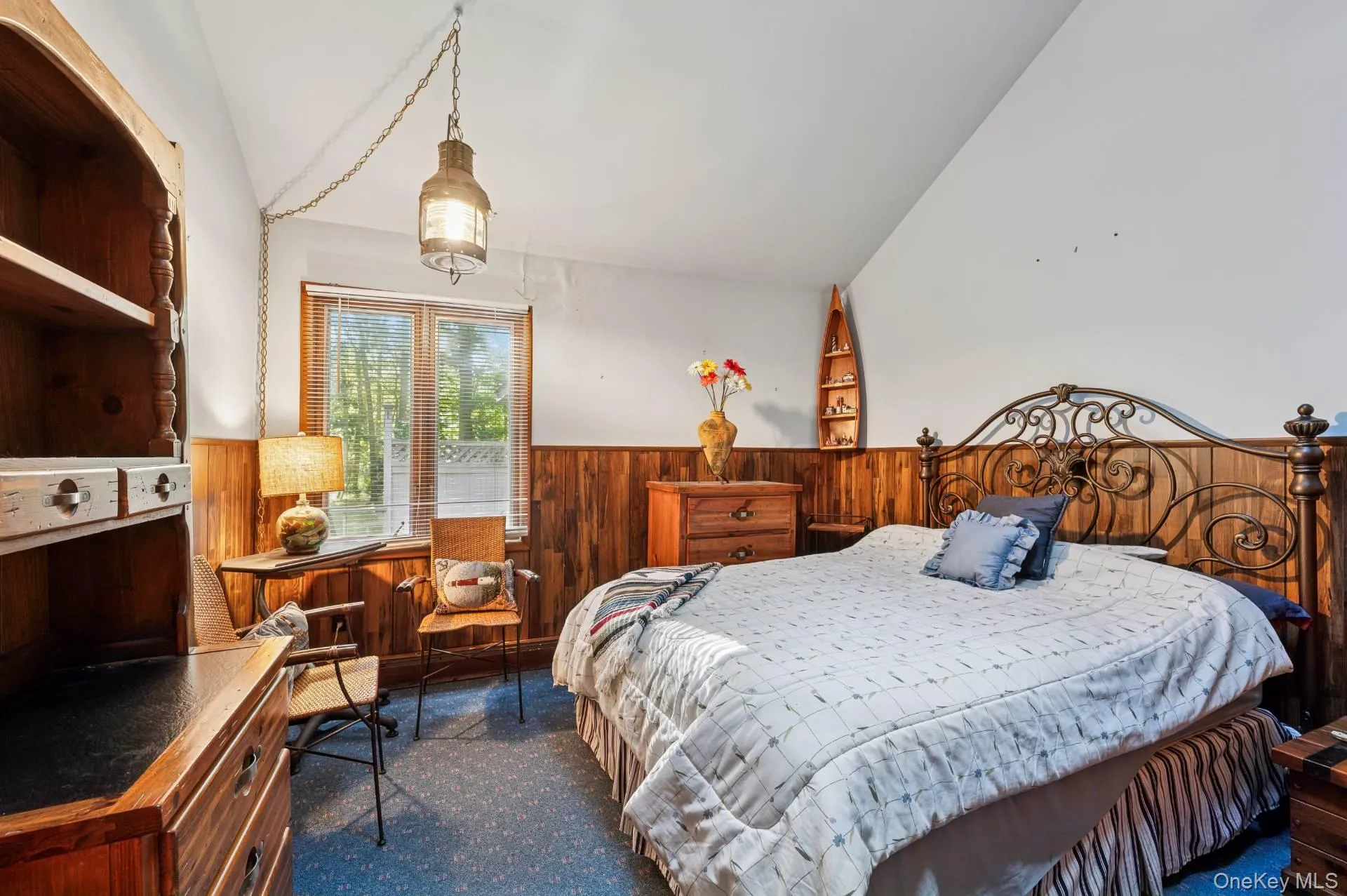 Bedroom with wood walls, a wainscoted wall, dark colored carpet, and lofted ceiling Bedroom with wood walls, a wainscoted wall, dark colored carpet, and lofted ceiling